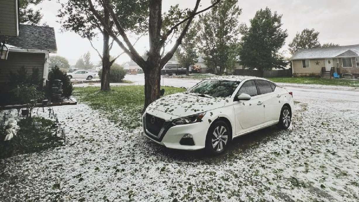 A car sits outside a home after a hailstorm hit Iron County, on Sunday.