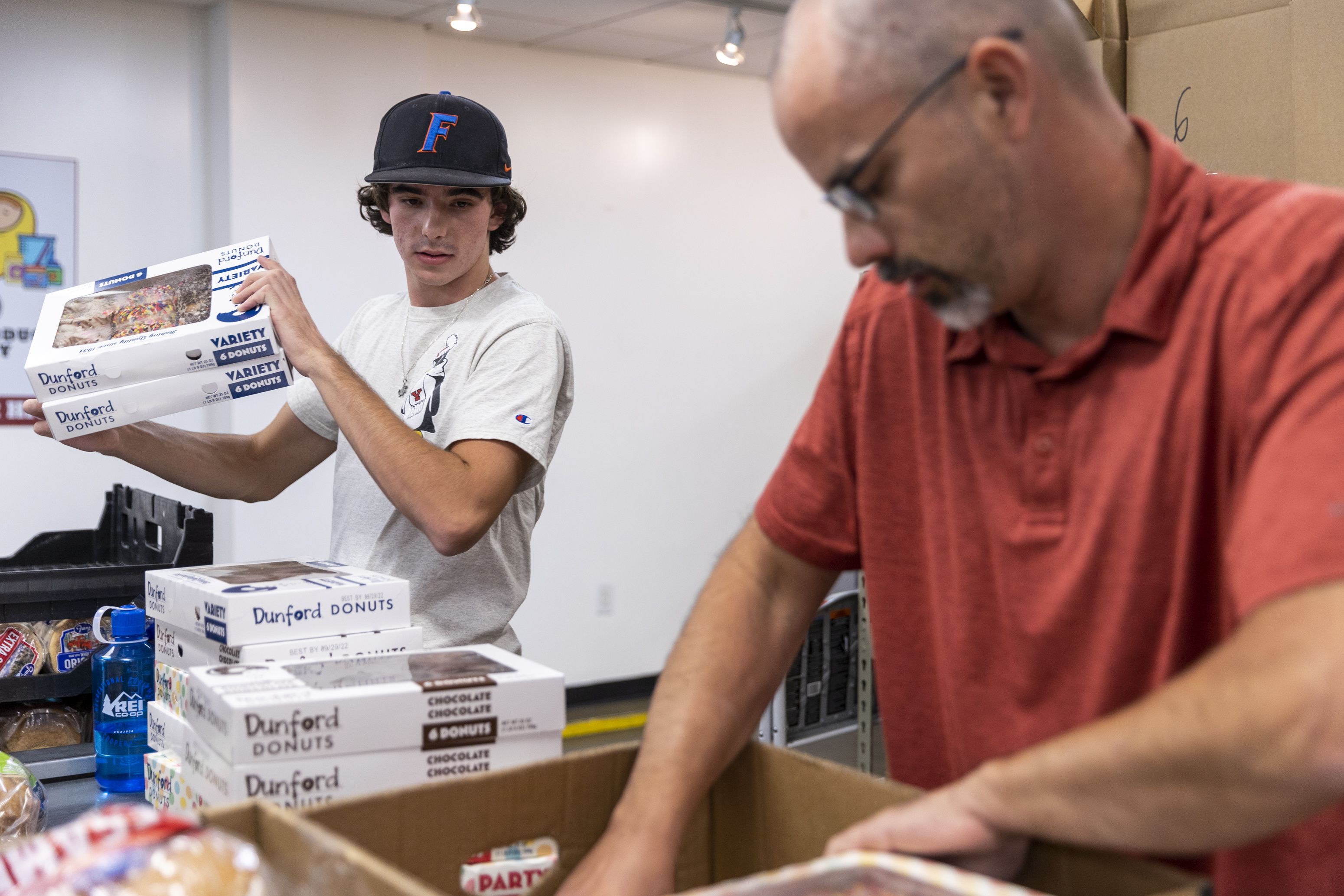 Alex Puccio, left, volunteers with his father, Rick Puccio, at the Utah Food Bank in Salt Lake City on Monday. Restrictions during the COVID-19 pandemic decimated the volunteer corps that many nonprofit and community outreach groups rely on, bringing some organizations to a monthslong standstill.