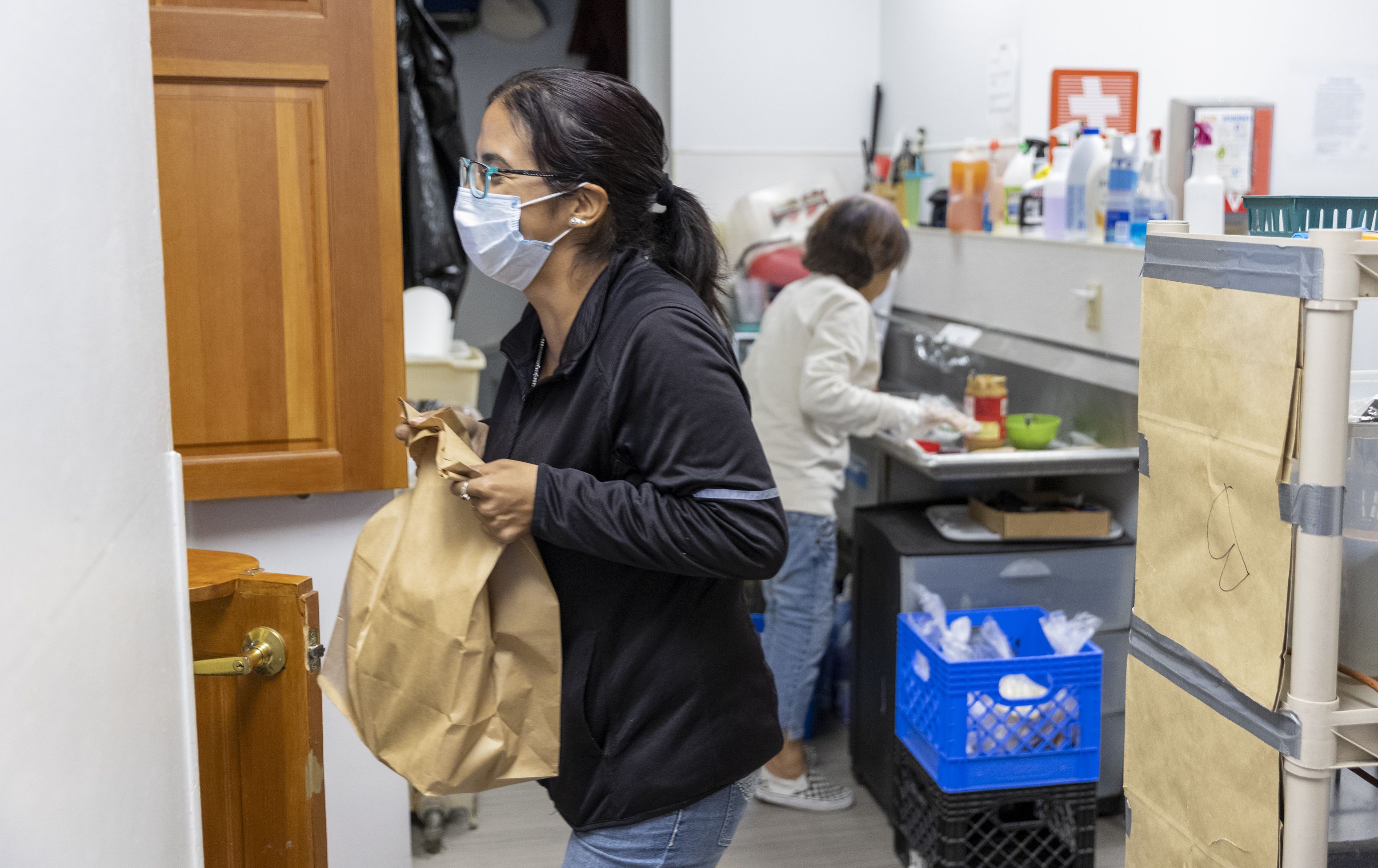 Volunteer Barbra Benward brings a cook box to a client at the Crossroads Urban Center in Salt Lake City on Monday. The cook box is filled with different foods and given to clients who have access to a kitchen.