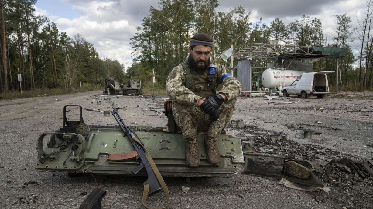 A Ukrainian serviceman smokes a cigarette after he found and identified a dead body of a comrade in recently recaptured town of Lyman, Ukraine, Monday.