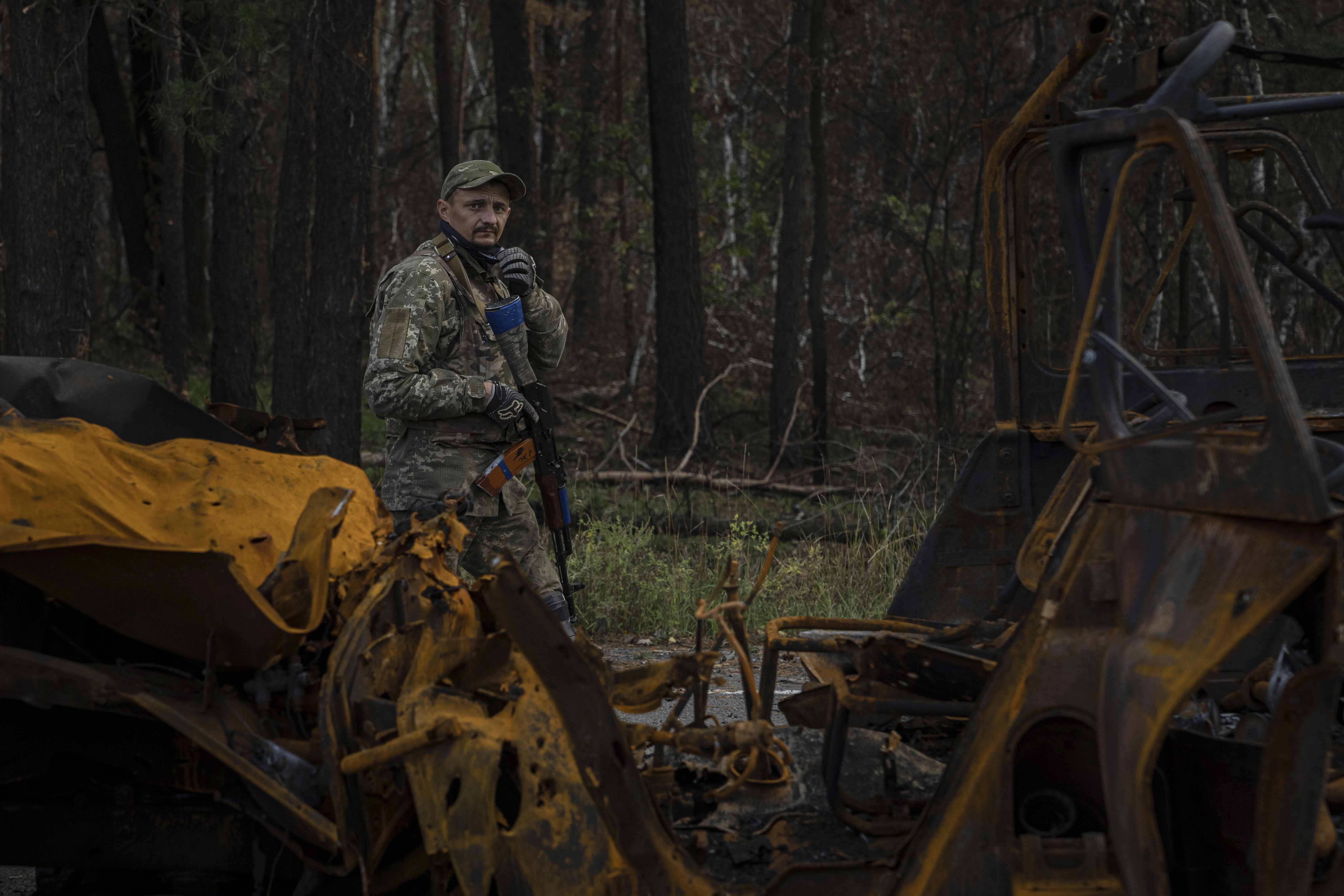 A Ukrainian serviceman walks along road while searching for dead bodies of his comrades in recently recaptured town of Lyman, Ukraine, Monday.