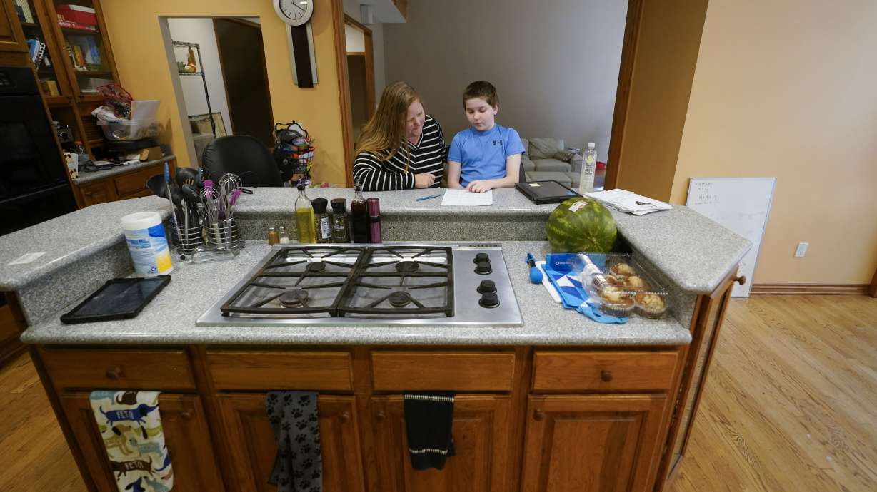 Lisa Manwell works on school work with her son John Jinks, 12, at their home in Canton, Mich., Sept. 21. Manwell says her son was improperly removed from his classroom last year because of behaviors that stemmed from his disability.