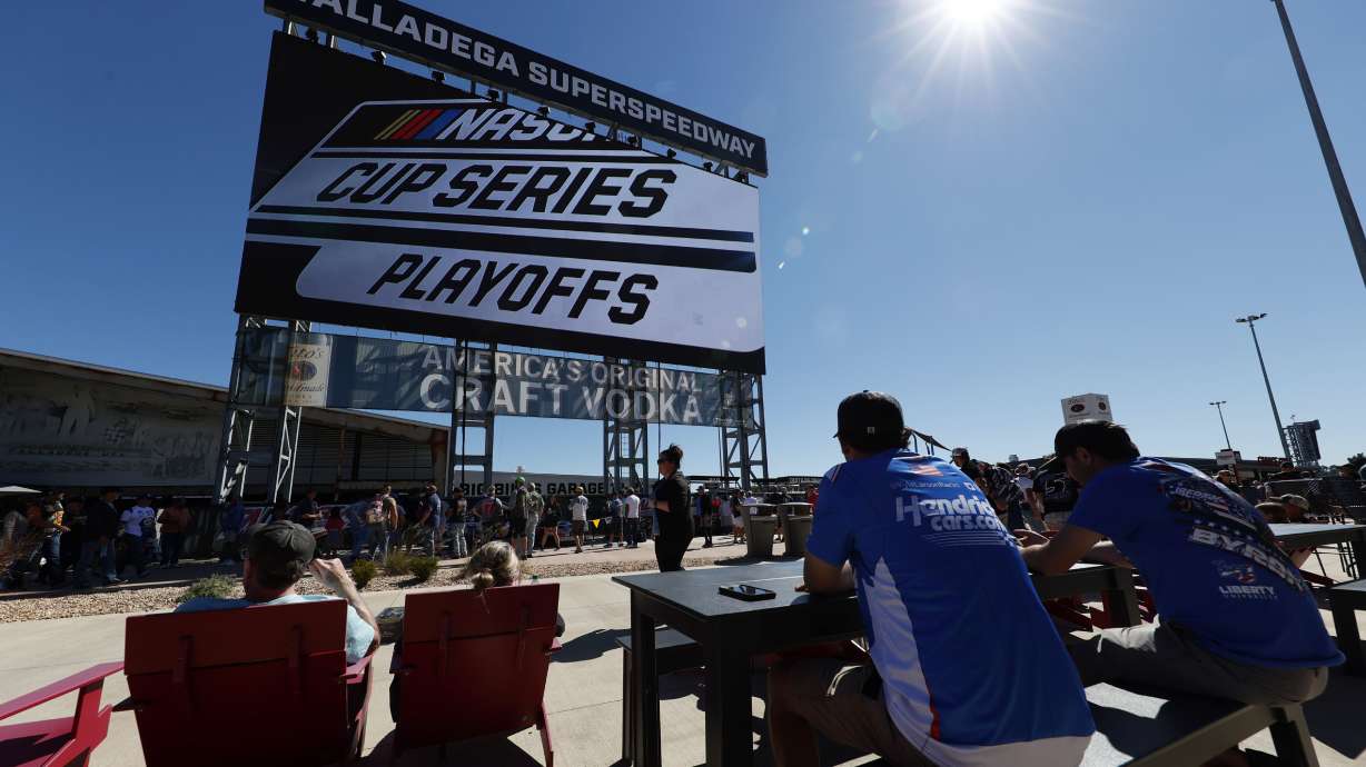 Fans eat and watch the big screen before the NASCAR Cup Series auto race Sunday, Oct. 2, 2022, in Talladega, Ala.