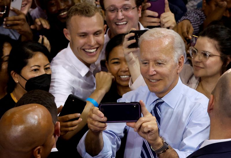 U.S. President Joe Biden takes a selfie during a Democratic National Committee rally at Richard Montgomery High School in Rockville, Maryland, U.S., Aug. 25. Biden's public approval rating edged lower this week and was close to the lowest level of his presidency, with just five weeks to go before the Nov. 8 midterm elections, a Reuters/Ipsos opinion poll completed on Tuesday found.