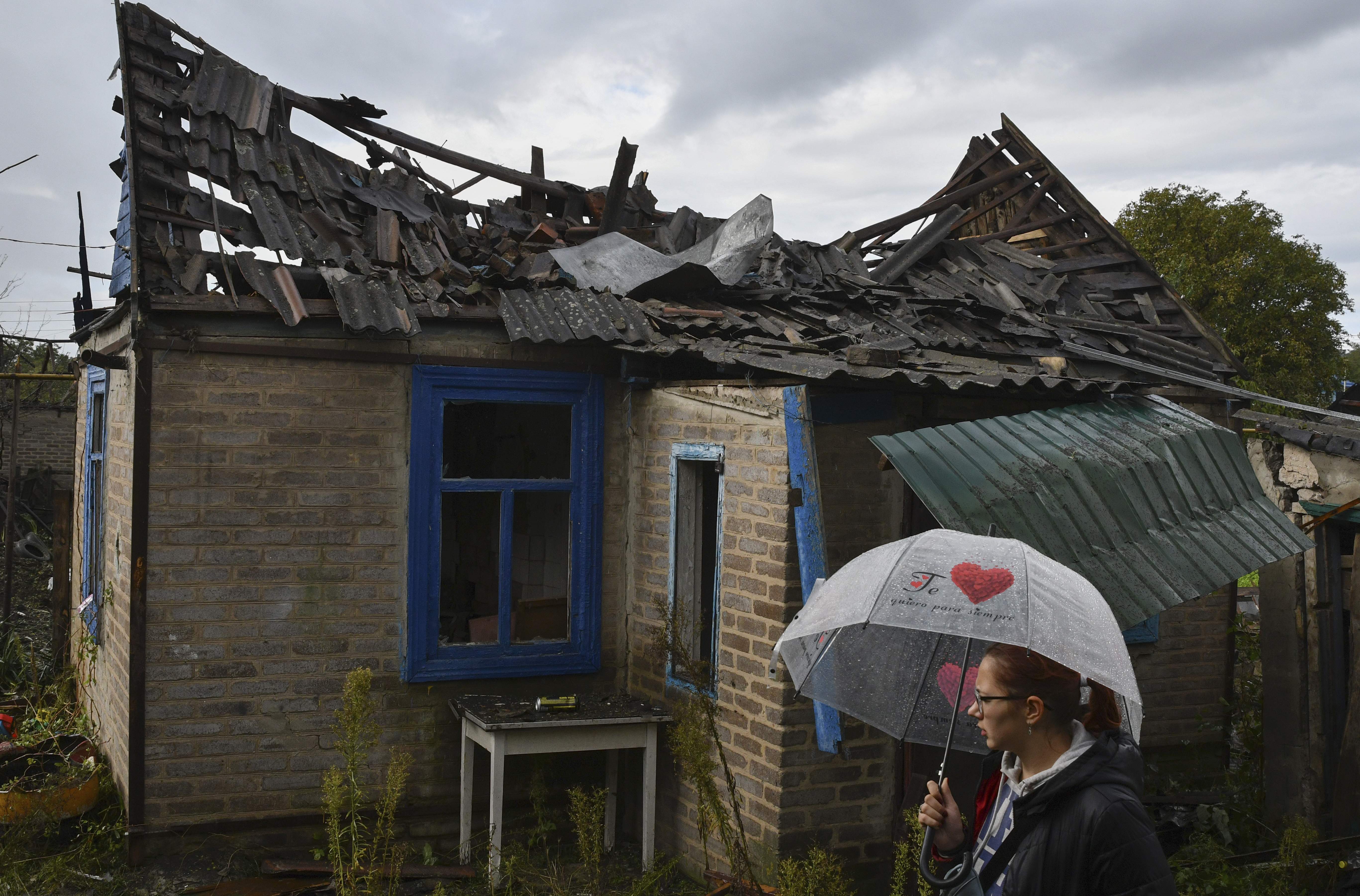 Local resident Ekaterina, 22, stands next to her residential building that was damaged after an overnight Russian attack in Kramatorsk, Ukraine, Tuesday. Russian President Vladimir Putin signed the final papers to annex four regions of Ukraine while his military struggled to control the new territory. In a defiant move, the Kremlin held the door open for further land grabs in Ukraine.