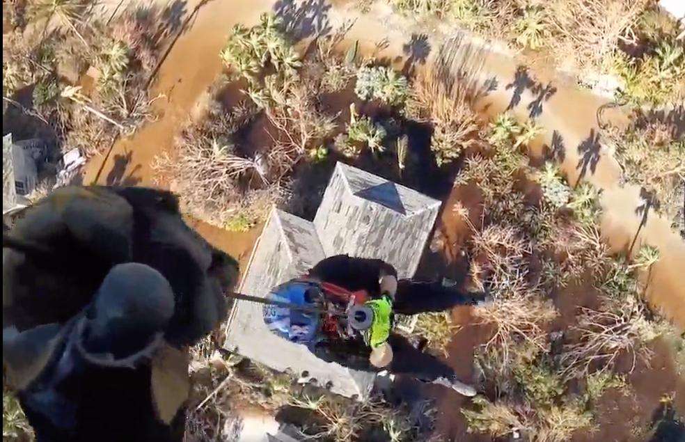 U.S. Coast Guard members lift people from the flooded debris left in Hurrican Ian's wake in Fort Meyers, Florida.