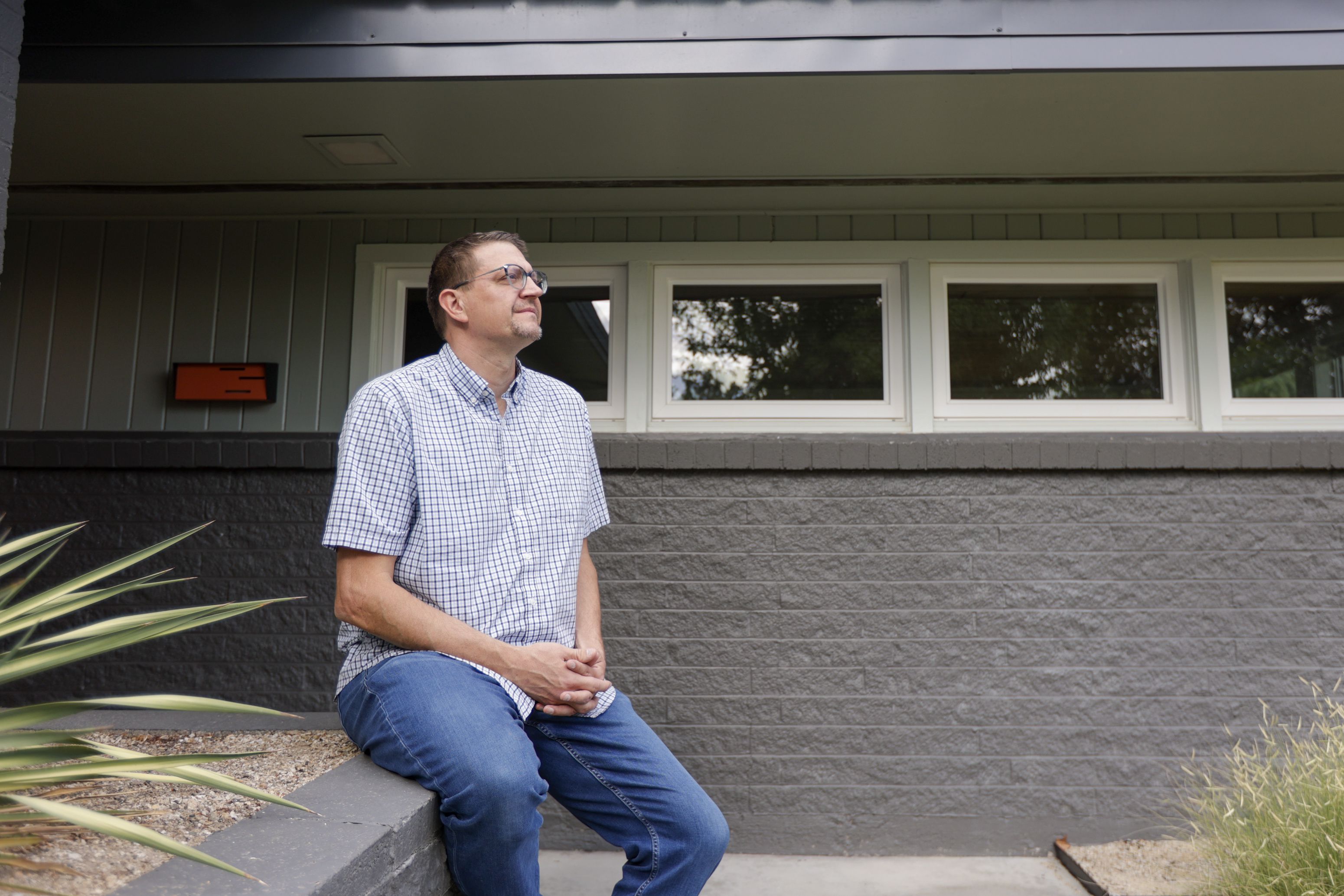 TJ Pierce, a real estate agent specializing in midcentury homes in Boise, sits in front of one of his listings on West Robertson Drive in Boise on Sept. 22. Pierce has noticed a dip in housing sales but doesn’t “expect to see a 2008 again” and does expect the prices to come down a bit.