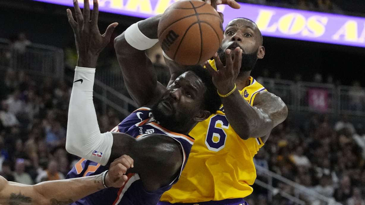 Phoenix Suns center Deandre Ayton (22) and Los Angeles Lakers forward LeBron James (6) battle for the ball during the first half of a preseason NBA basketball game Wednesday, Oct. 5, 2022, in Las Vegas.