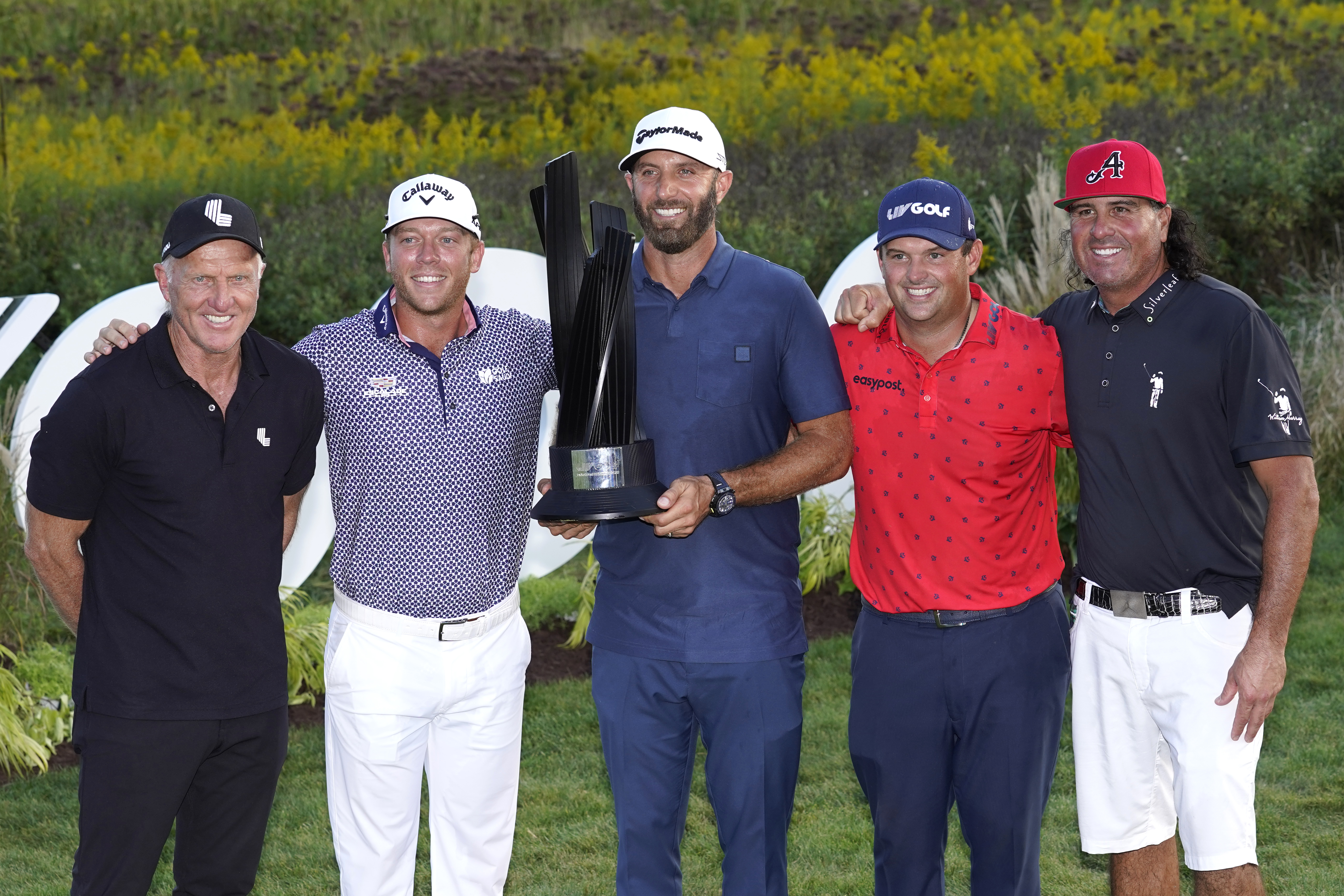 LIV Golf CEO Greg Norman, left, stands with the 4 Aces GC team, from left, Talor Gooch, Captian Dustin Johnson, Patrick Reed and Pat Perez, after winning the team's fourth straight tournament at the LIV Golf Invitational-Chicago tournament Sunday, Sept. 18, 2022, in Sugar Hill, Ill.