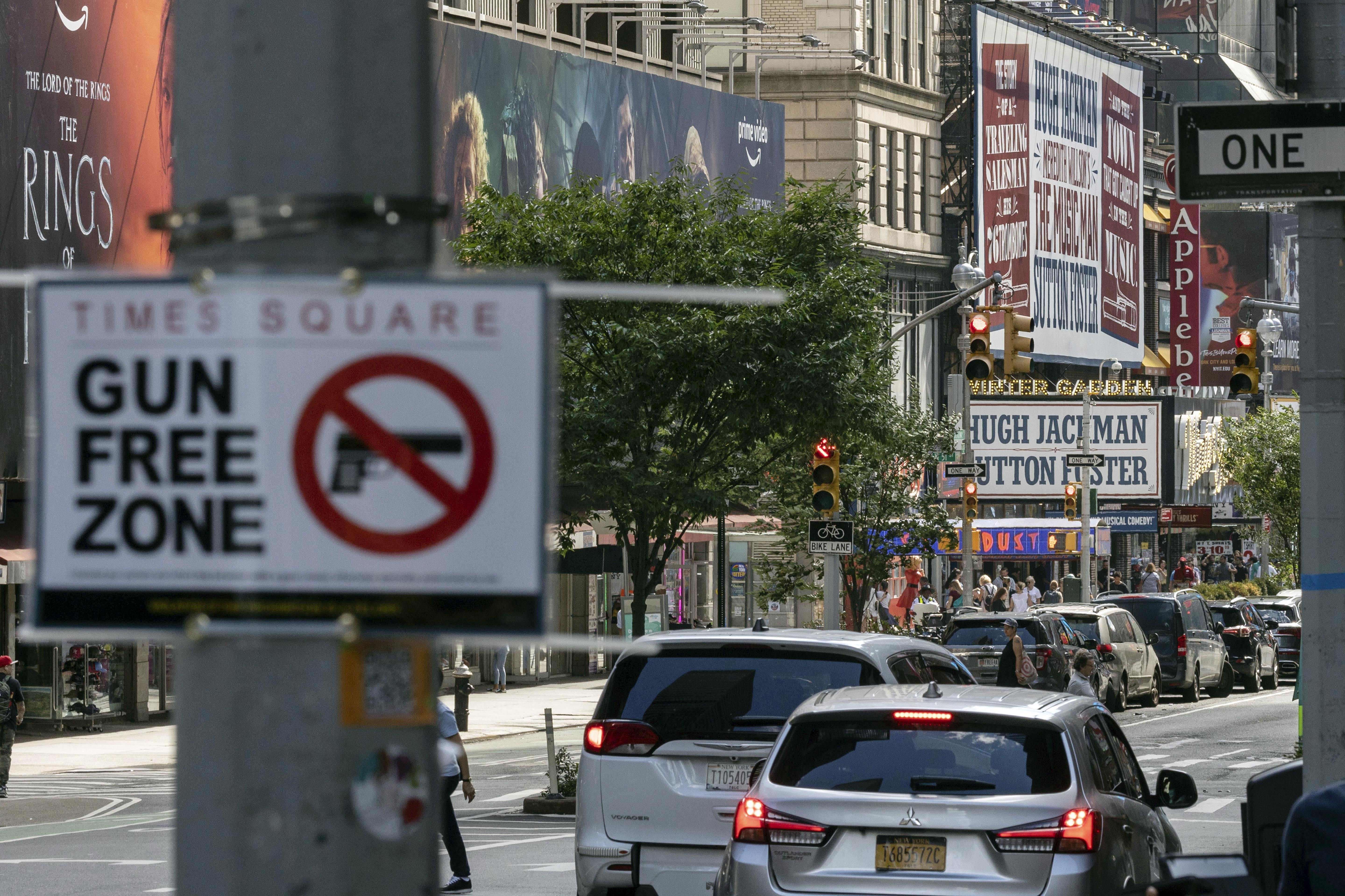 A sign reading "Gun Free Zone" is posted near around Times Square, Aug. 31, in New York. A federal judge said Thursday that New York gun rules that dramatically restrict where people can carry weapons and require concealed carry permit applicants to hand over social media information should be put on hold.