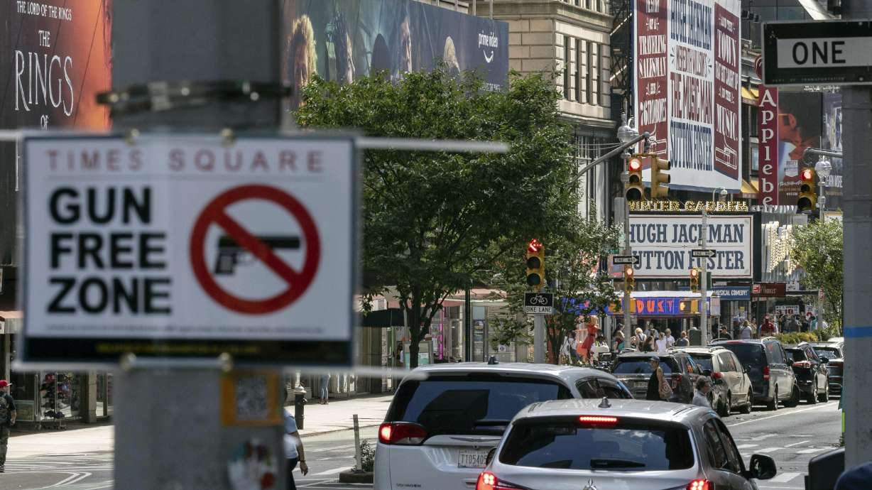 A sign reading "Gun Free Zone" is posted near around Times Square, Aug. 31, in New York. A federal judge said Thursday that New York gun rules that dramatically restrict where people can carry weapons and require concealed carry permit applicants to hand over social media information should be put on hold.
