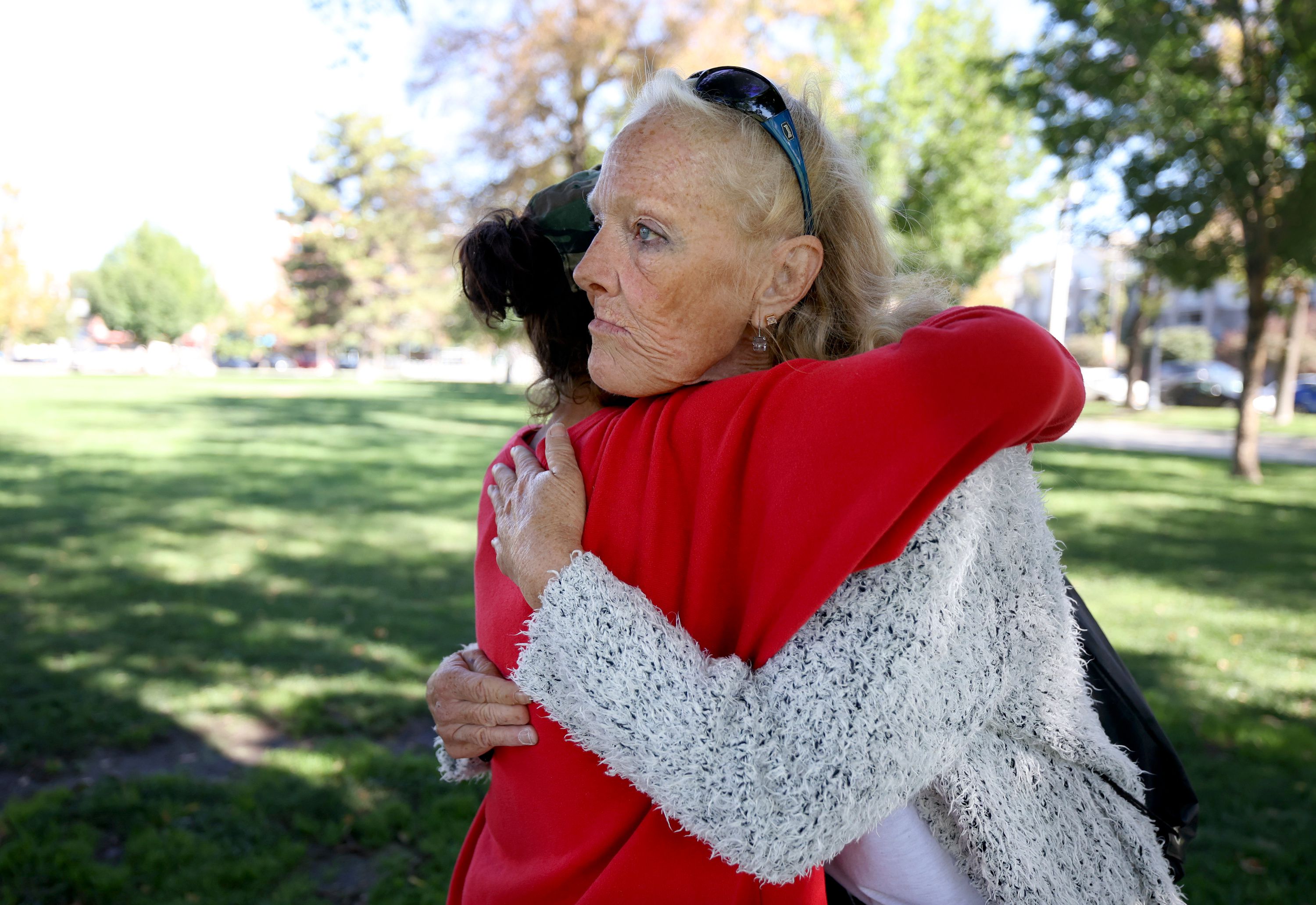 Jeralyn Delamare, who is homeless, gets a hug from her friend Teresa Marzocca in Pioneer Park in Salt Lake City on Thursday.