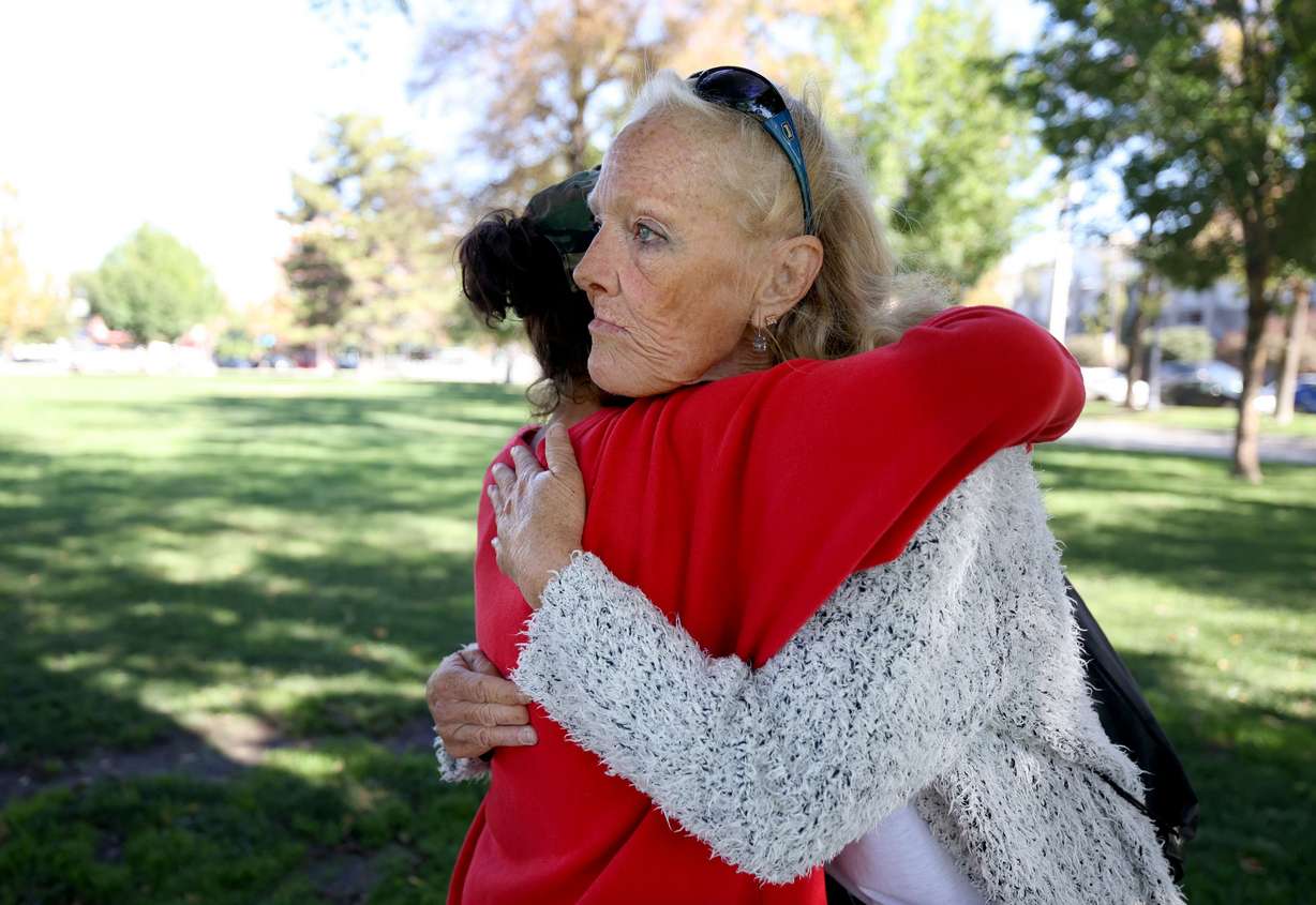 Jeralyn Delamare, who is homeless, gets a hug from her friend Teresa Marzocca in Pioneer Park in Salt Lake City on Thursday.