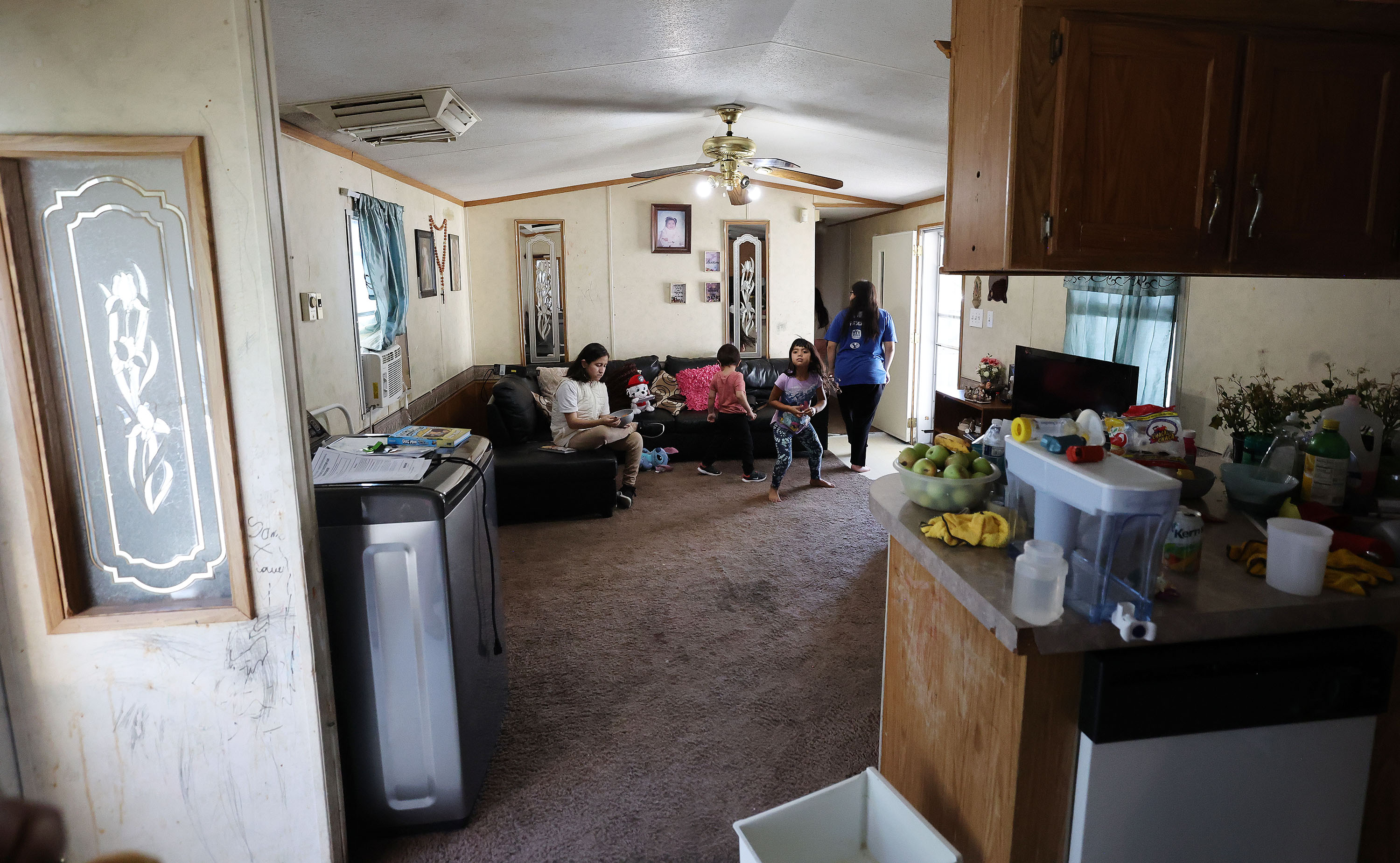Susana Estrada’s children and some friends sit in the front room at their trailer park home in Provo on Wednesday. Estrada and her family are immigrants including five children who are disabled. They were going to lose their home until the Fuller Center for Housing of Utah County stepped in to help with repairs.