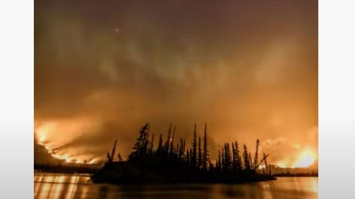 Chetamon Mountain wildfire with visible auroras at Jasper National Park, in Alberta, Canada.