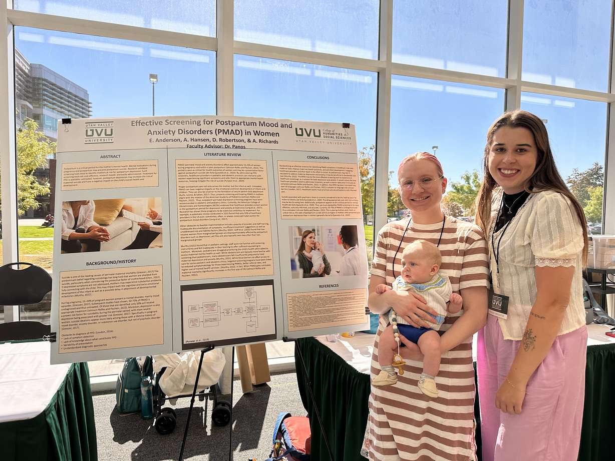 UVU graduate students Emily Anderson, right, and Devon Robertson, holding her baby Darrow, share their research on the gap of health care for maternal mental health after delivery. Their presentation was part of UVU's Suicide Prevention Conference on Friday.