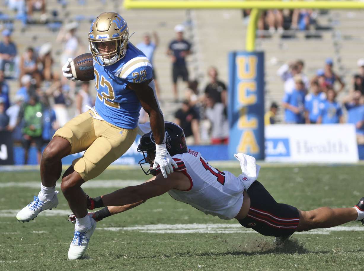 UCLA Bruins running back Keegan Jones (22) runs past Utah Utes safety R.J. Hubert (11) at the Rose Bowl in Pasadena, CA, on Saturday, Oct. 8, 2022.