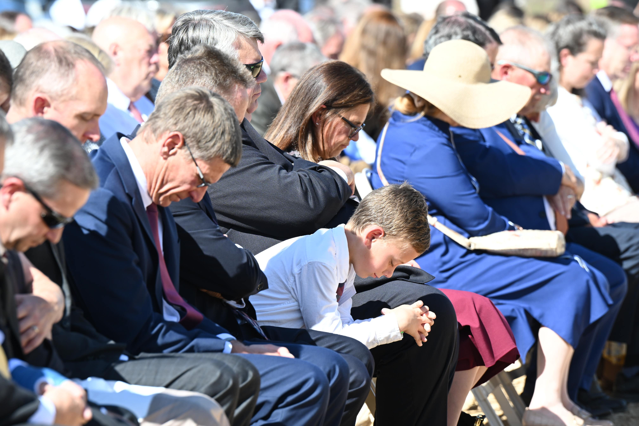 Members of The Church of Jesus Christ of Latter-day Saints bow their heads in prayer as the land where the church's Heber Valley Utah Temple will be constructed in Heber City on Saturday.
