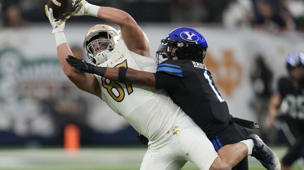 Notre Dame tight end Michael Mayer (87) makes a catch over BYU defensive back Micah Harper (1) during the first half of an NCAA college football game Saturday, Oct. 8, 2022, in Las Vegas.