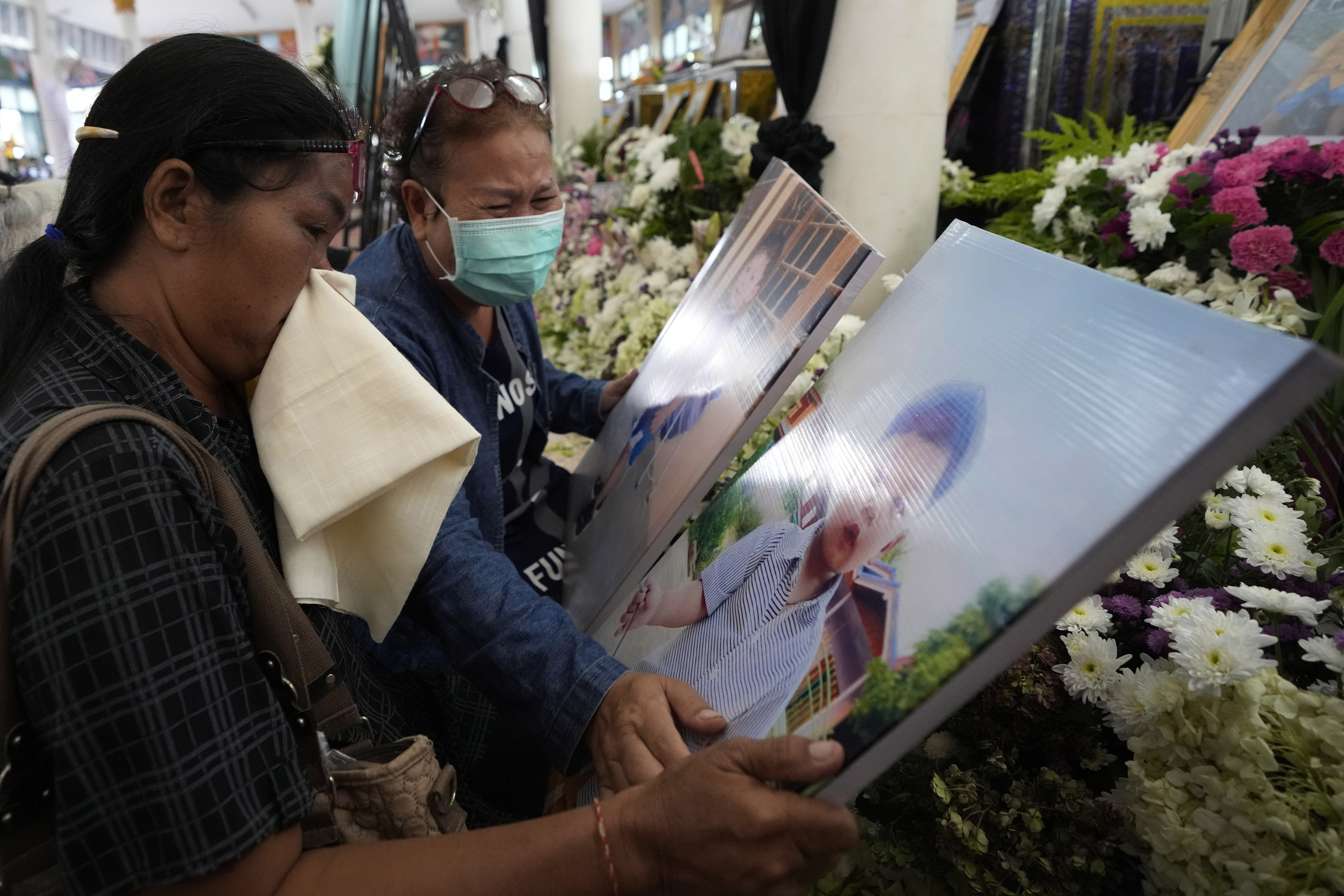 Relatives of the victims of a mass killing attack gather for a Buddhist ceremony inside Wat Rat Samakee temple in the rural town of Uthai Sawan, north eastern Thailand, Sunday. A former police officer burst into a day care center in northeastern Thailand on Thursday, killing dozens of preschoolers and teachers before shooting more people as he fled. 