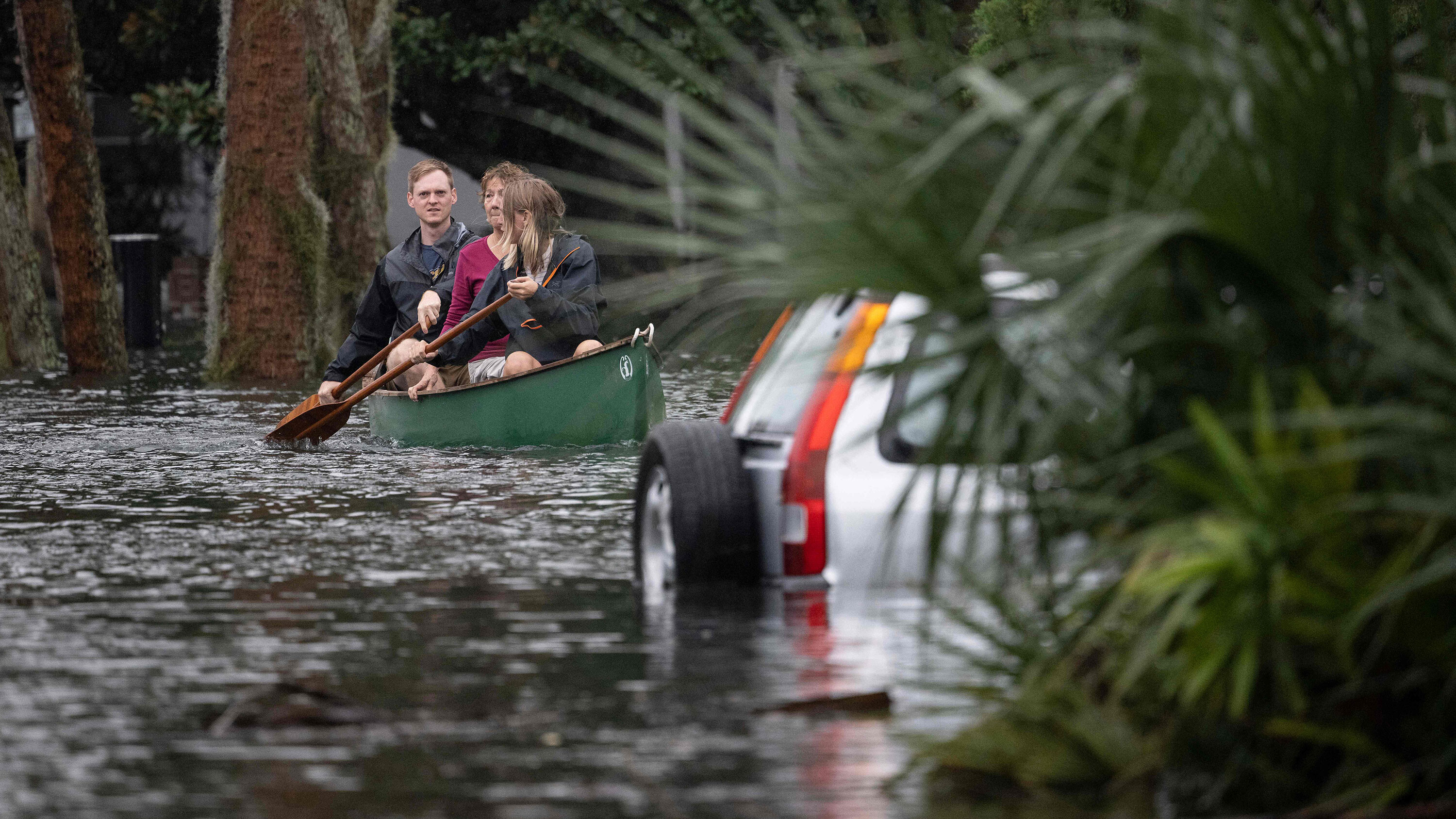 People paddle by in a canoe next to a submerged car in the aftermath of Hurricane Ian in Orlando on Sept. 29.
