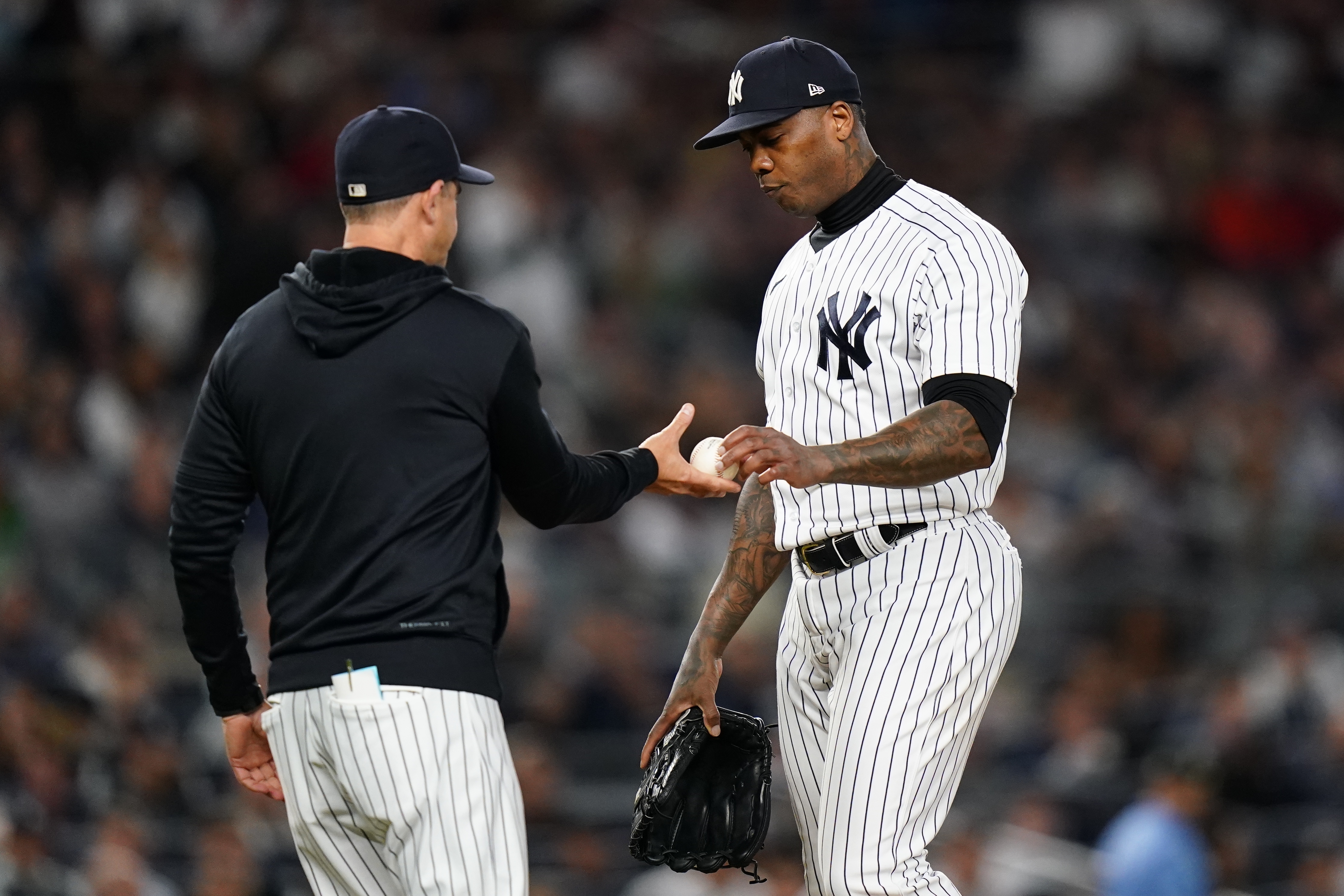 New York Yankees relief pitcher Aroldis Chapman hands the ball to manager Aaron Boone during the eighth inning of a baseball game against the Boston Red Sox Thursday, Sept. 22, 2022, in New York. 