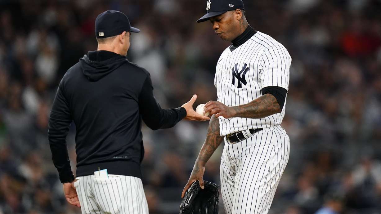 New York Yankees relief pitcher Aroldis Chapman hands the ball to manager Aaron Boone during the eighth inning of a baseball game against the Boston Red Sox Thursday, Sept. 22, 2022, in New York.