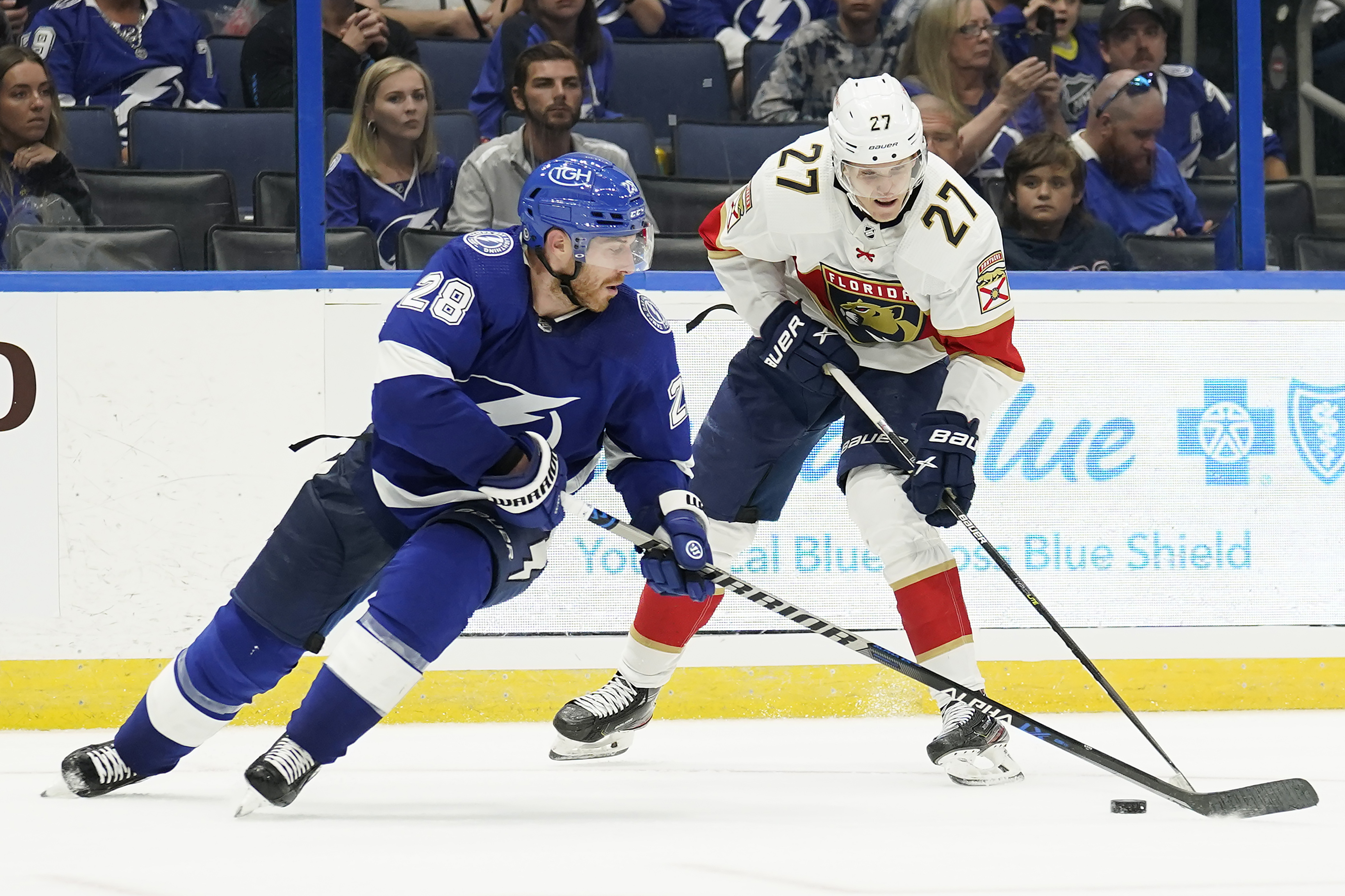 Florida Panthers center Eetu Luostarinen (27) works around Tampa Bay Lightning defenseman Ian Cole (28) during the third period of an NHL preseason hockey game Saturday, Oct. 8, 2022, in Tampa, Fla. 