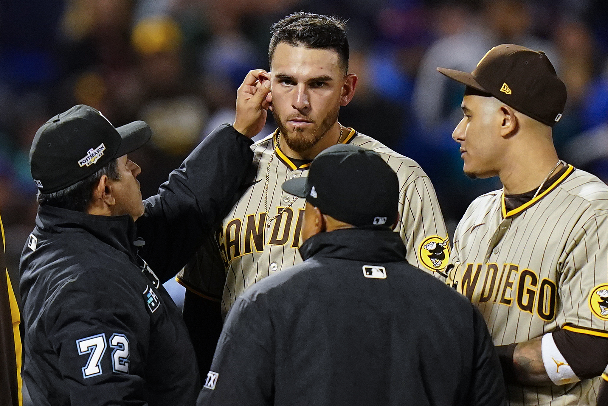 Umpire Alfonso Marquez (72) checks for substances behind the ears of San Diego Padres starting pitcher Joe Musgrove (44) during the sixth inning of Game 3 of a National League wild-card baseball playoff series against the New York Mets, Sunday, Oct. 9, 2022, in New York.
