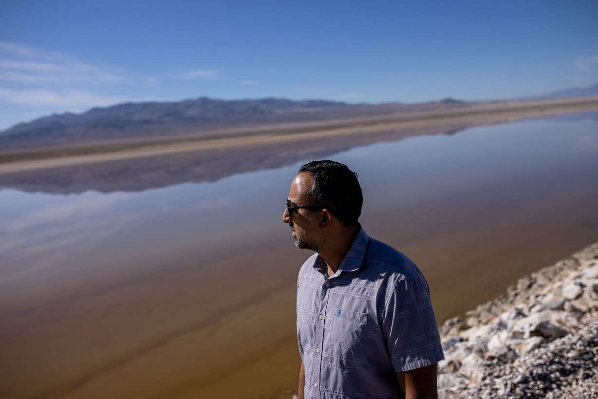 Arrash Agahi, who oversees regulatory compliance of Owens Lake for the Los Angeles Department of Water and Power, looks at an area of the lakebed that has been converted to a brine pool to reduce blowing dust while giving journalists a tour of the project area on Aug. 11.