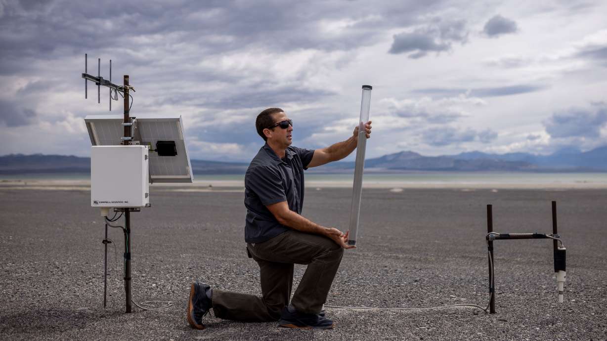 Phill Kiddoo, air pollution control officer for the Great Basin Unified Air Pollution Control District, shows journalists a tube that collects fine particulate, one measure of how much is being blown around in the wind, at an air quality monitoring site on the north shore of Mono Lake in Mono County, California, on Aug. 9.