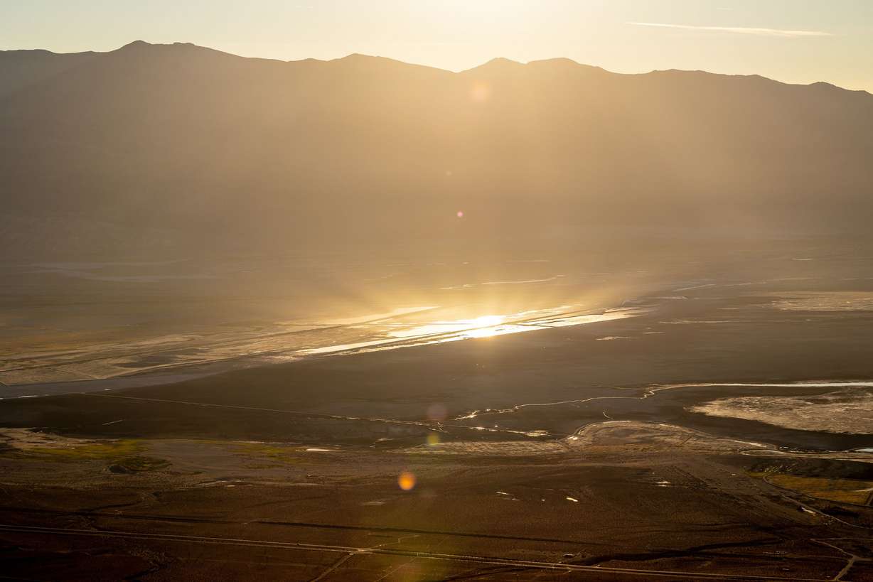 The rising sun reflects off of pools of water and brine that are part of the Owens Lake Dust Mitigation Program on the mostly dry lakebed in Inyo County, Calif., on Aug. 12.