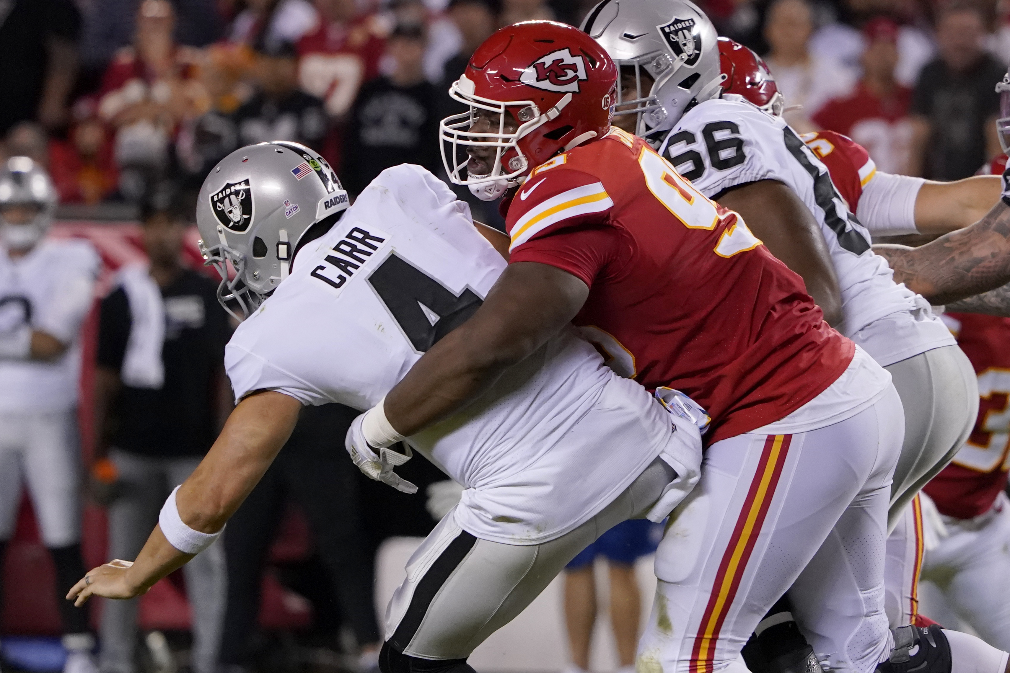 Las Vegas Raiders quarterback Derek Carr (4) is sacked by Kansas City Chiefs defensive tackle Chris Jones, right, during the first half of an NFL football game Monday, Oct. 10, 2022, in Kansas City, Mo. 