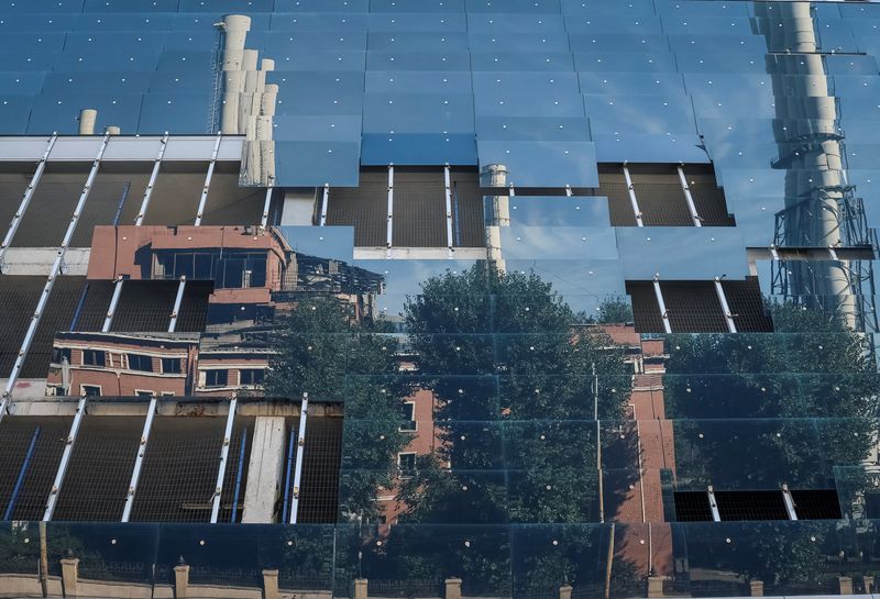 A damaged thermal plant is reflected in the remaining windows of a damaged business centre after the previous day's Russian military strike, as Russia's invasion of Ukraine continues, in central Kyiv, Ukraine, on Tuesday.
