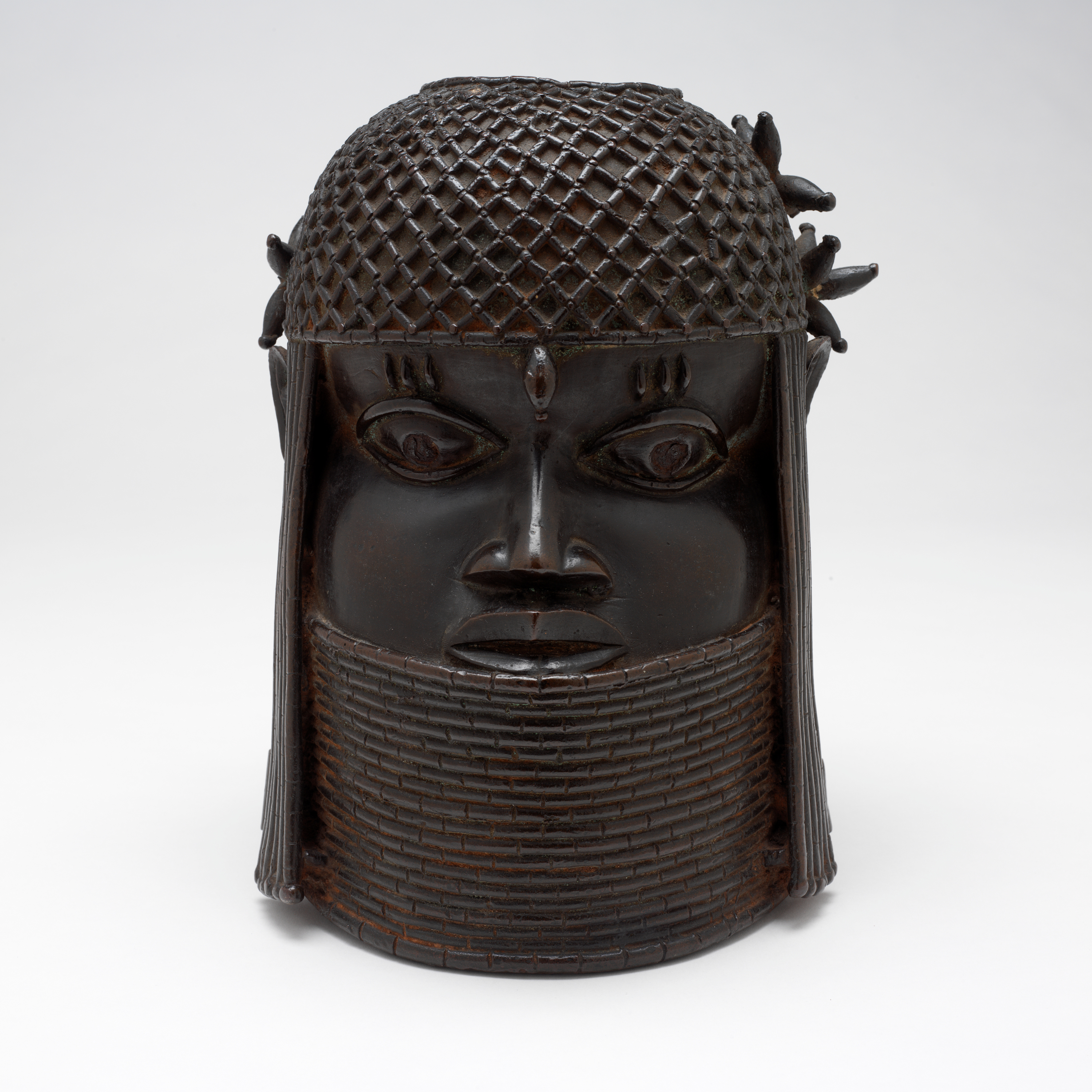 A bronze sculpture called the "Head of a King" or "Oba," probably from the 1700s, rests in front of a white background, December 2004, in Providence, R.I. The sculpture was among 31 culturally precious objects that were looted by the British in the late 19th century and were returned to the Nigerian government, Oct. 11. 