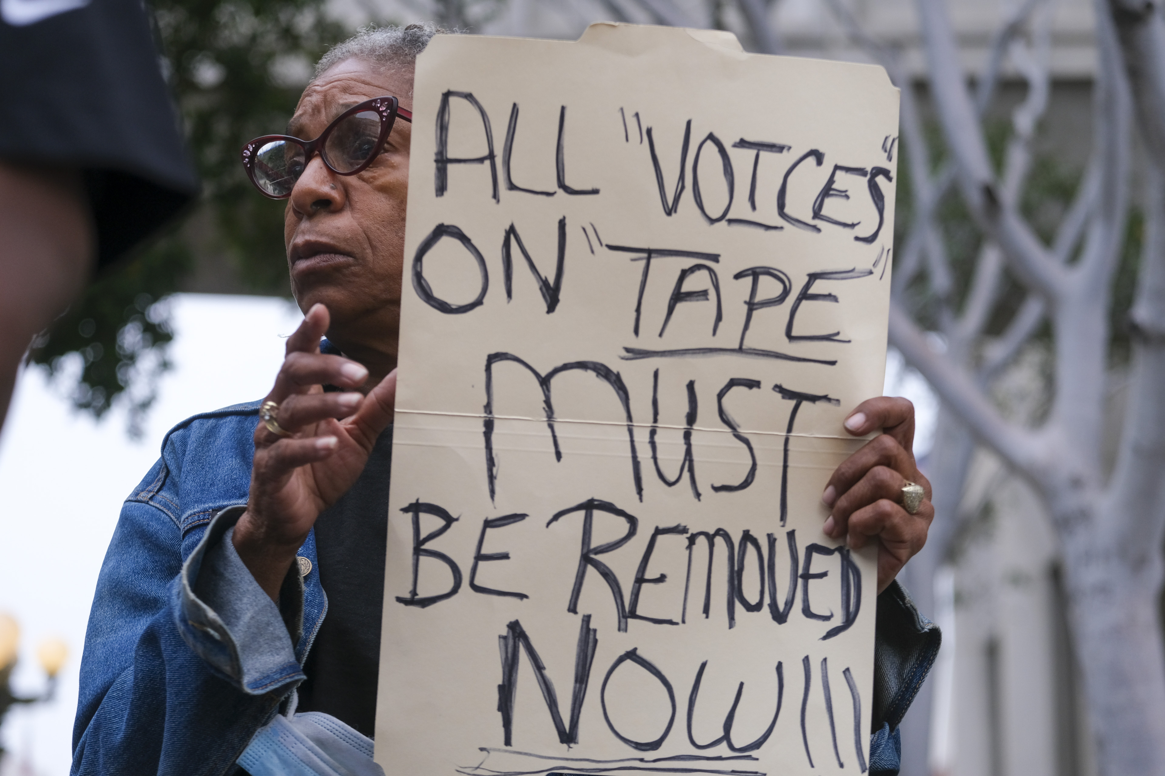Veronica Sance holds a sign in a news conference to denounce racism and demand change in response to a recorded, racially charged leaked conversation between leaders at City Hall and the Los Angeles County Federation of Labor President, before the Los Angeles City Council meeting outside city hall, Tuesday in Los Angeles .