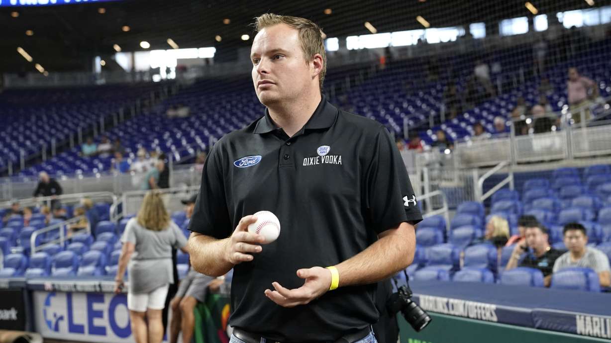 NASCAR driver Cole Custer holds a baseball before throwing a ceremonial pitch before a baseball game between the Miami Marlins and Chicago Cubs, Monday, Sept. 19, 2022, in Miami.
