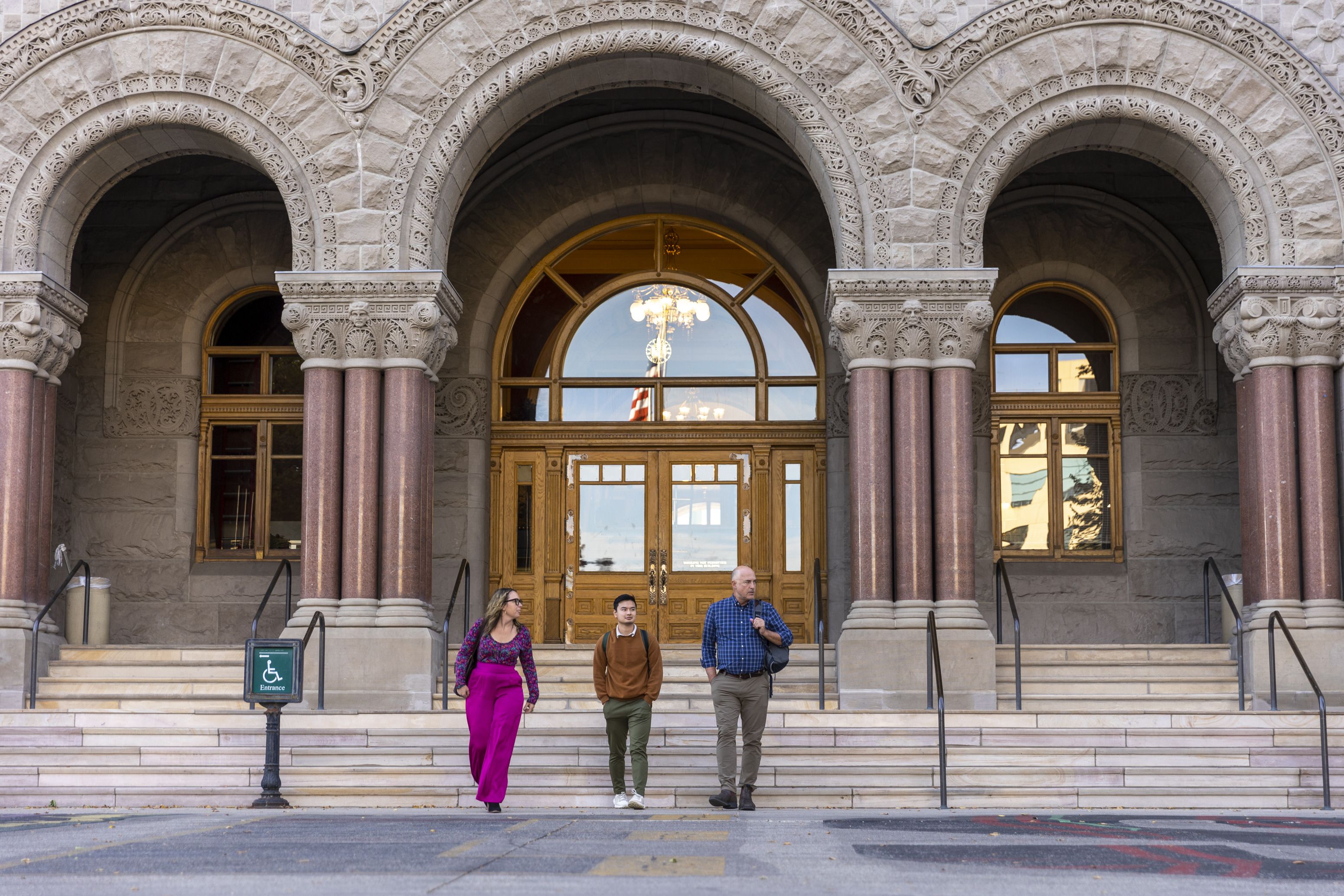 Angela Price, left, Victor Tran, middle, and David Driskell, right, leave the Salt Lake City and County Building after having meetings in Salt Lake City on Tuesday.