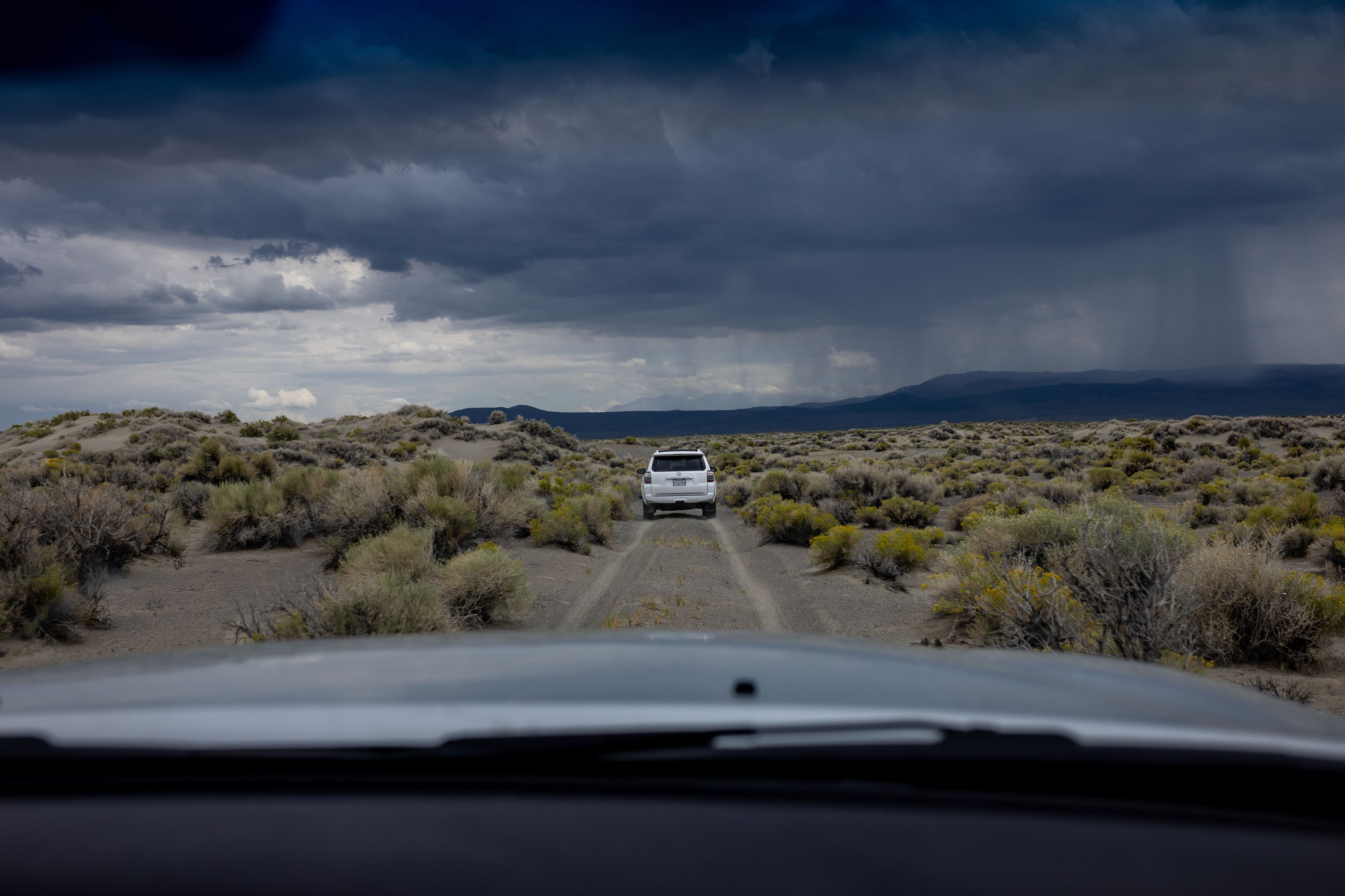 Phill Kiddoo, air pollution control officer for the Great Basin Unified Air Pollution Control District, pilots his car ahead of Geoffrey McQuilkin, executive director of the Mono Lake Committee, while they take journalists to see an air quality monitoring site on the north shore of Mono Lake in Mono County, Calif., on Aug. 9.