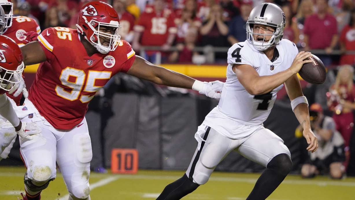 Las Vegas Raiders quarterback Derek Carr (4) scrambles away from Kansas City Chiefs defensive tackle Chris Jones (95) during the second half of an NFL football game Monday, Oct. 10, 2022, in Kansas City, Mo.