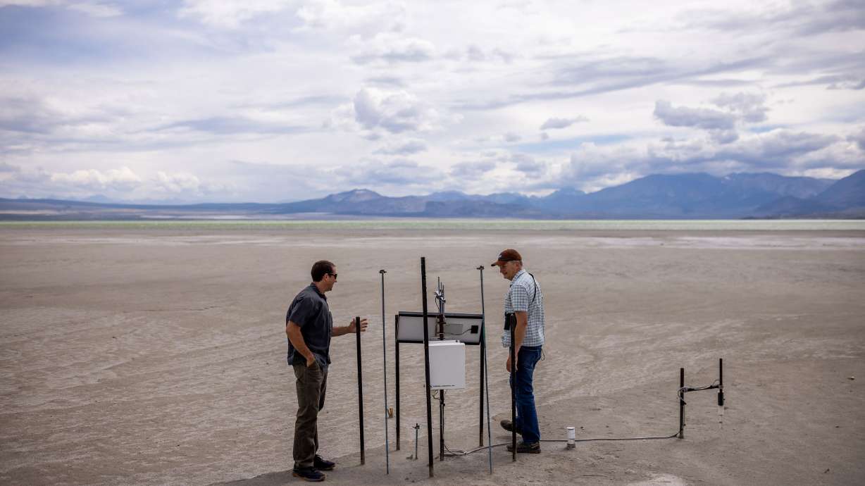 Phill Kiddoo, air pollution control officer for the Great Basin Unified Air Pollution Control District, and Geoffrey McQuilkin, executive director of the Mono Lake Committee, check out an air quality monitor while taking journalists on a tour of the north shore of Mono Lake in Mono County, California, on Tuesday, Aug. 9.