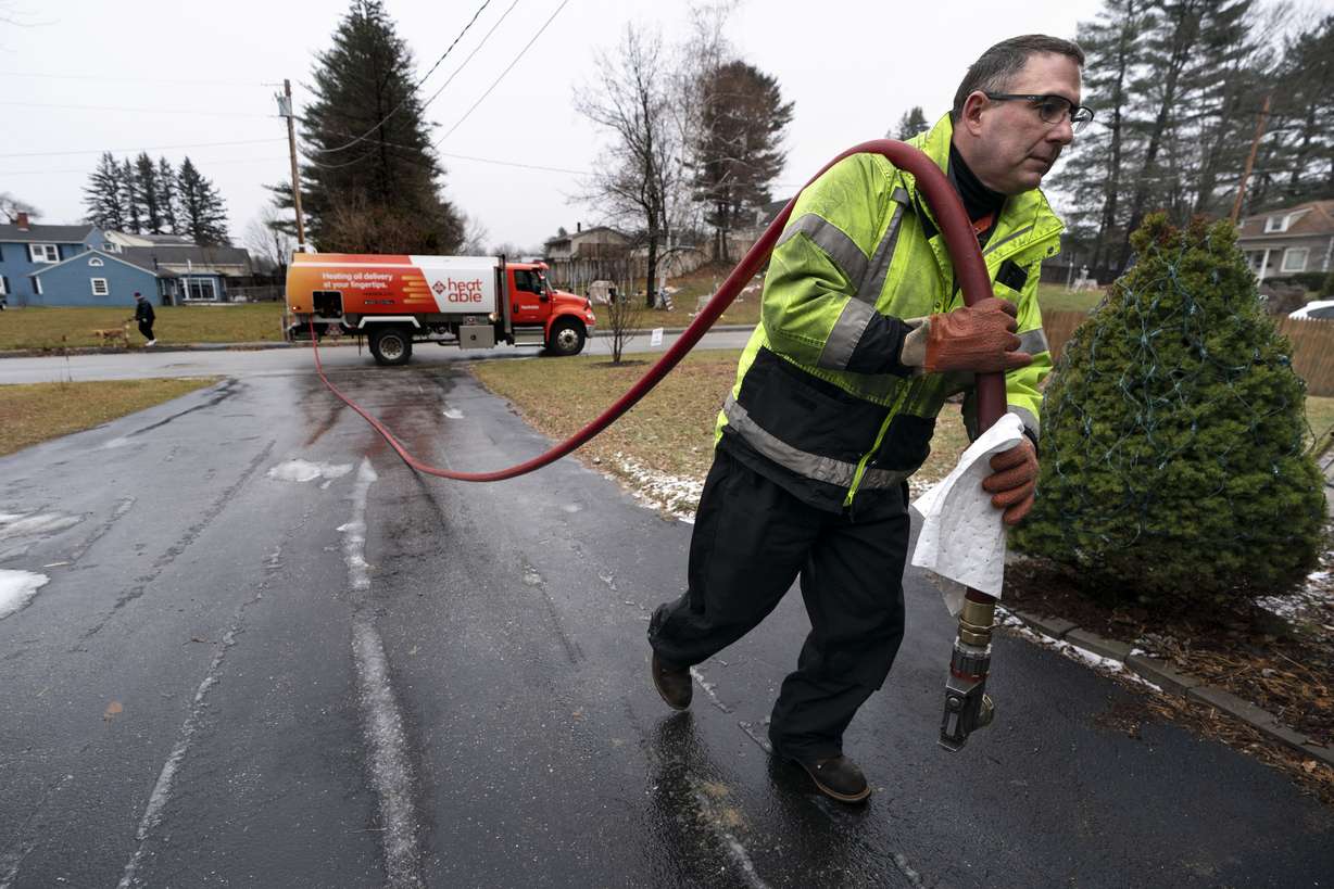 Daniel DiDonato, a deliveryman for Heatable, brings heating oil to a home in Lewiston, Maine, Dec. 16, 2021.
