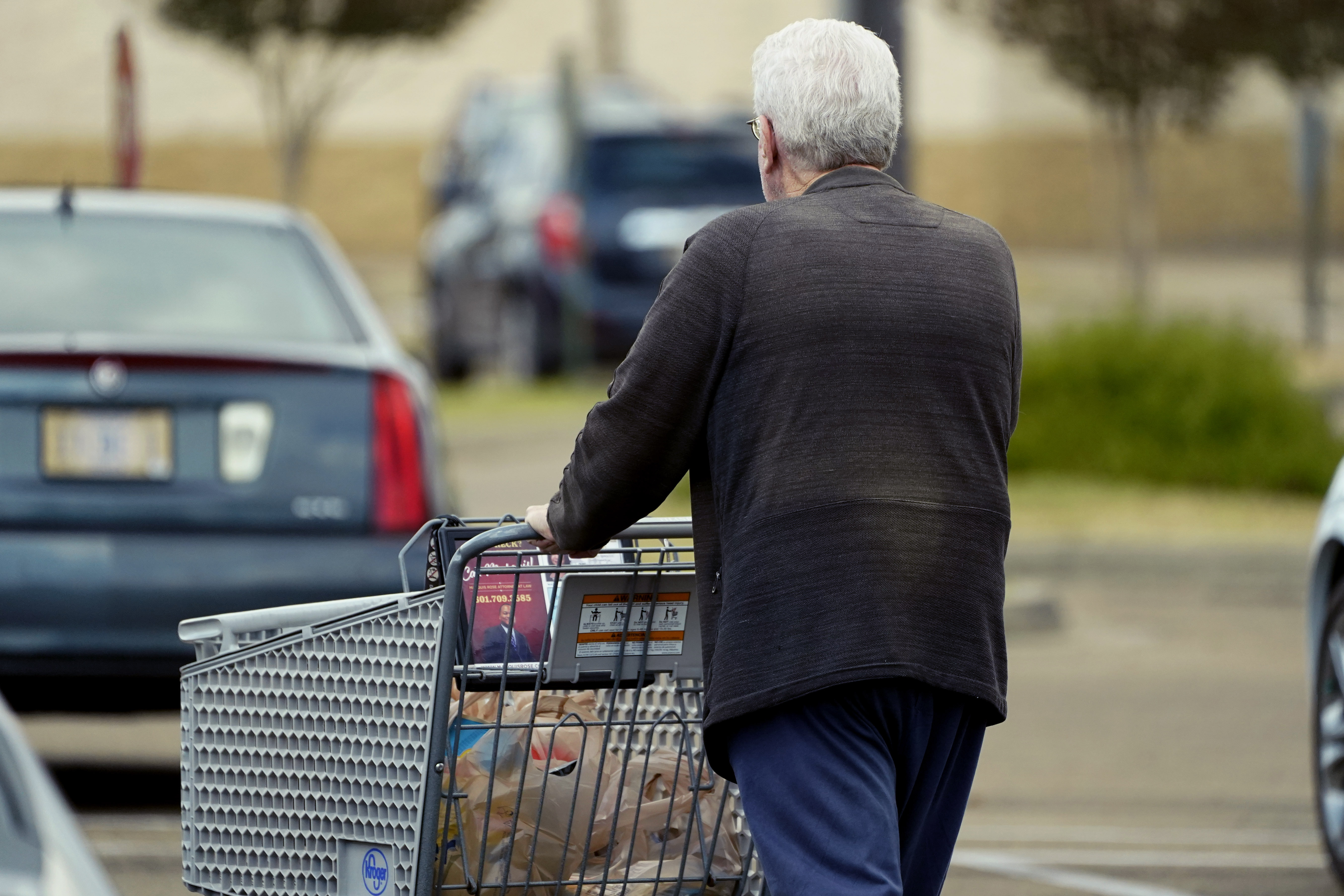 An older customer pushes his Kroger shopping cart laden with purchases in Jackson, Miss., Wednesday.