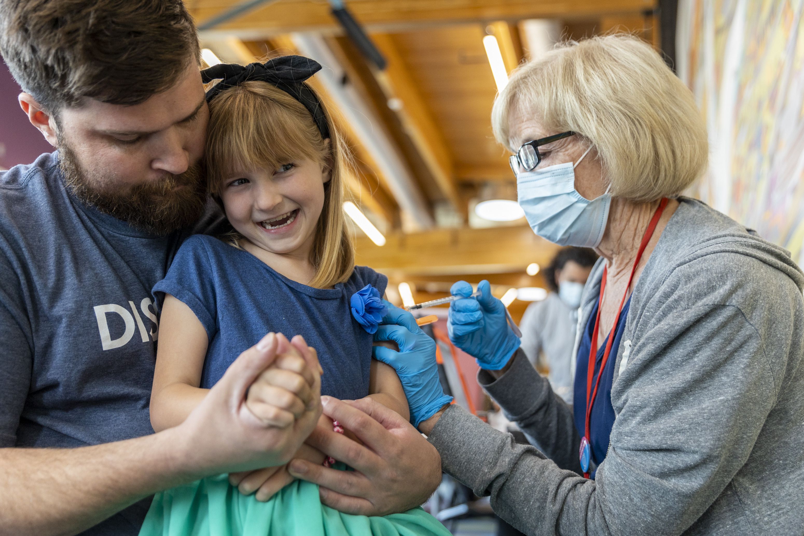 Nurse Cathy Martin administers a COVID-19 booster shot to Emmaline Park, 6, as she is held by her dad, Bryce, at the the Kearns Library in Kearns on Sept. 29.
