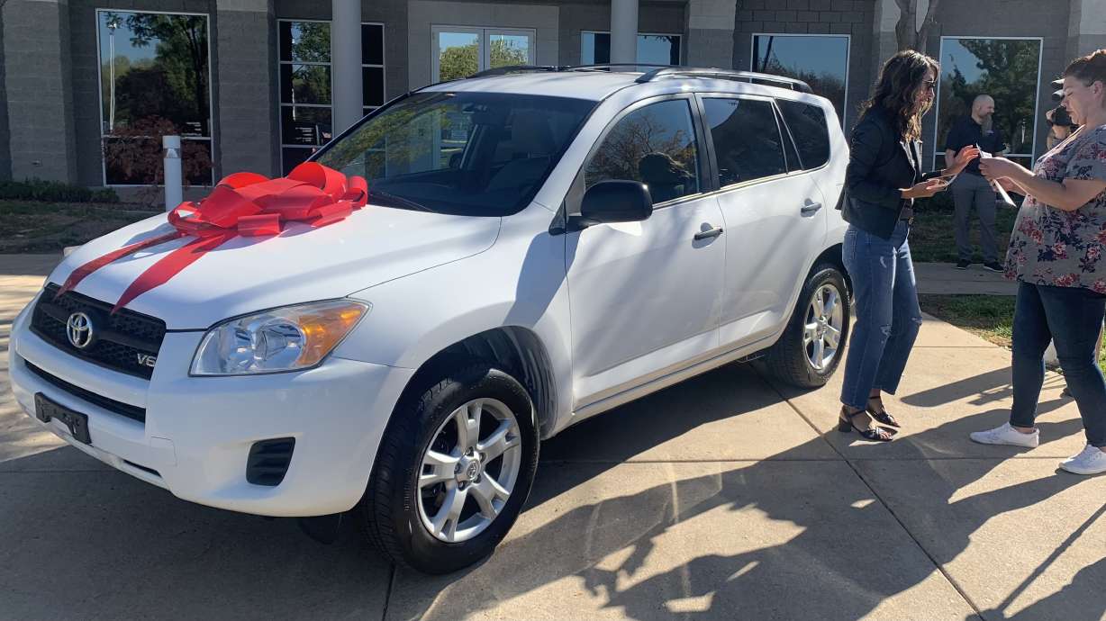 Nina Archuleta, right, and Jodie Klingensmith celebrate Archuleta receiving a free car. Nonprofit God's Garage partnered with America First Credit Union to give the single mom a new car on Thursday in Riverdale.
