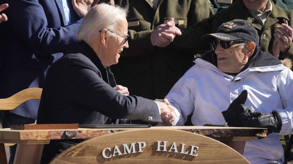 President Joe Biden greets Bob Scheuer, of Boulder, Colo., after Biden designated the first national monument of his administration at Camp Hale, a World War II era training site Wednesday, Oct. 12, 2022, near Leadville, Colo. Scheuer trained at the camp.