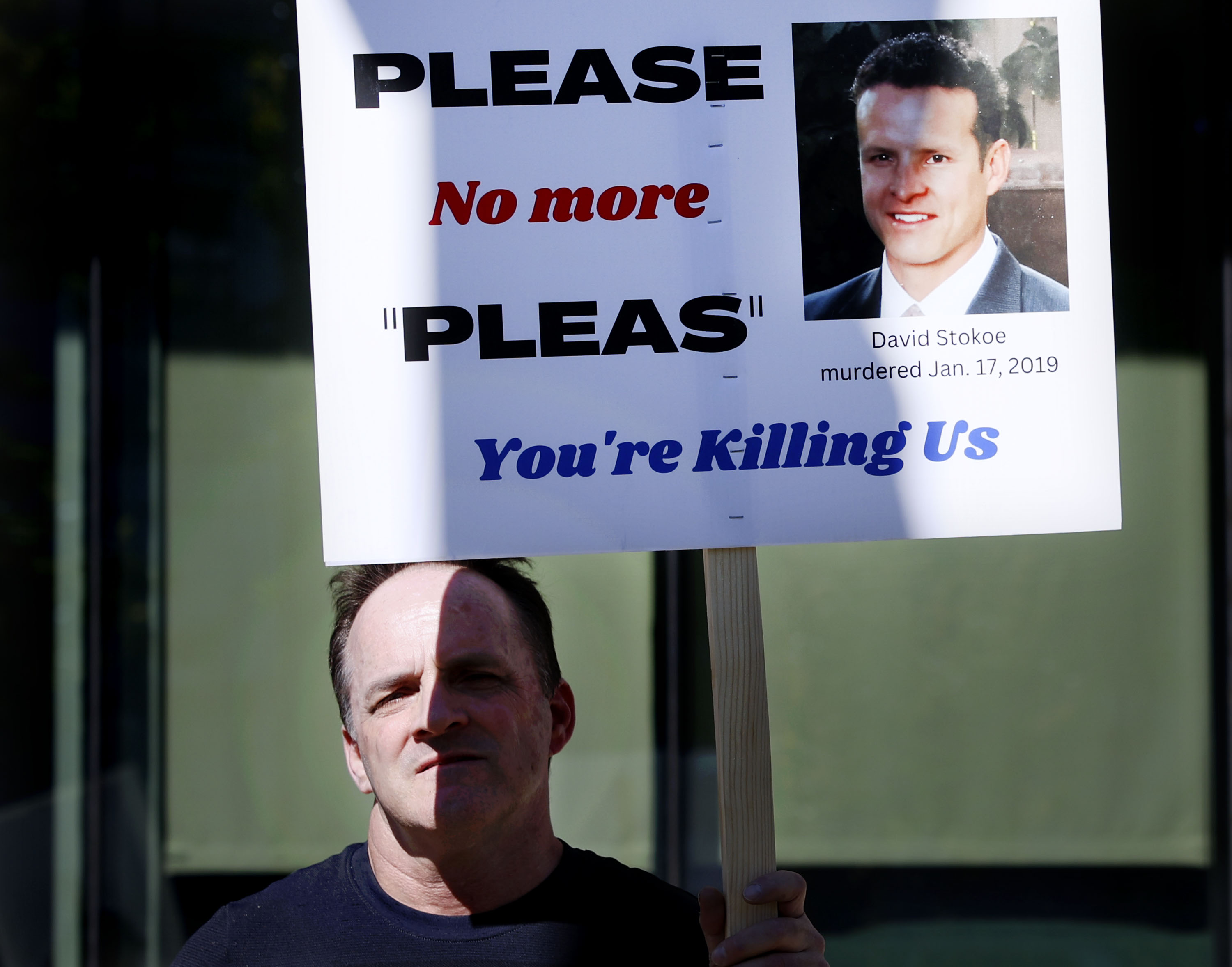 Dean Belov, a half-brother of David Stokoe, protests at the district attorney’s office in Salt Lake City on Oct. 13.