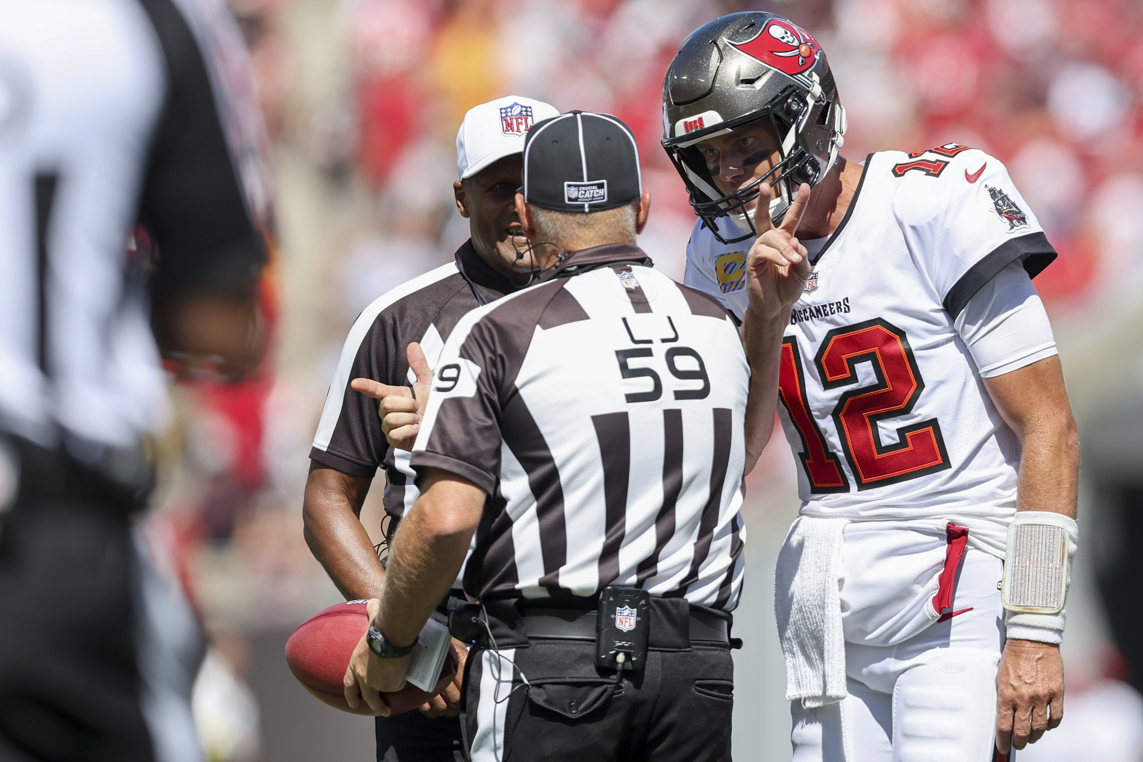 Line judge Rusty Baynes (59) speaks with Tampa Bay Buccaneers quarterback Tom Brady (12) during the first half of an NFL football game against the Atlanta Falcons, Sunday, Oct. 9, 2022, in Tampa, Fla. 