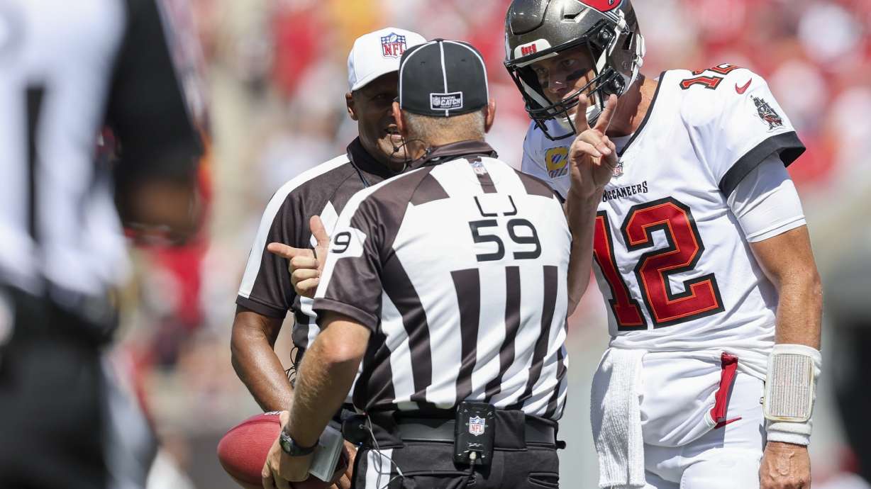 Line judge Rusty Baynes (59) speaks with Tampa Bay Buccaneers quarterback Tom Brady (12) during the first half of an NFL football game against the Atlanta Falcons, Sunday, Oct. 9, 2022, in Tampa, Fla.