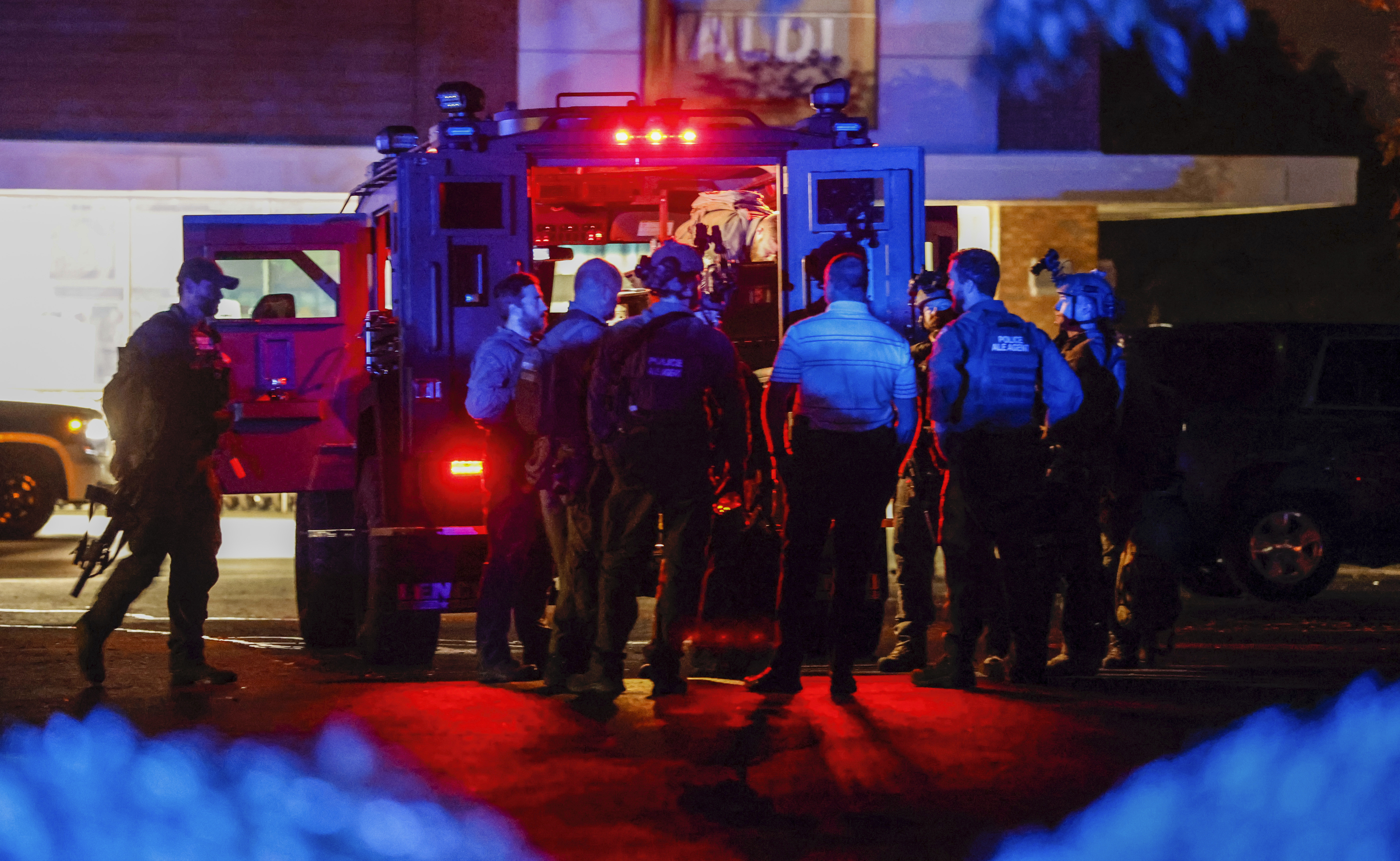 Law enforcement officers congregate outside an armored vehicle at the Aldi on New Bern Avenue in Raleigh after five people were shot and killed in the Hedingham Neighborhood and Nuese River Trail area in Raleigh, N.C., Thursday.